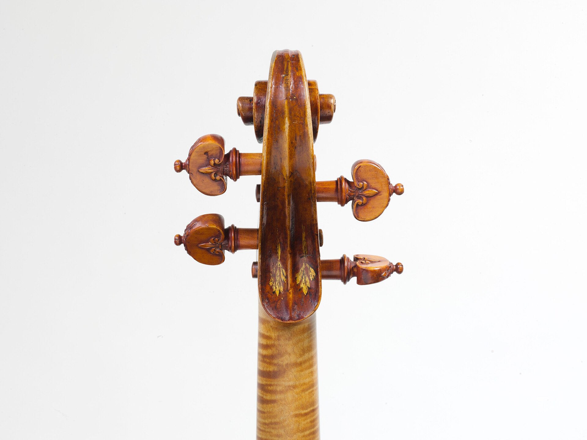 The pegbox and scroll of the ex-Kurtz violin by Andrea Amati, in the Metropolitan Museum of Art, photographed from the rear against a plain ground. Traces of painted decoration survive on the back of the pegbox. Museum custody is the end state this pattern tends towards: the instrument is preserved, photographed and documented, and it stops being played.
