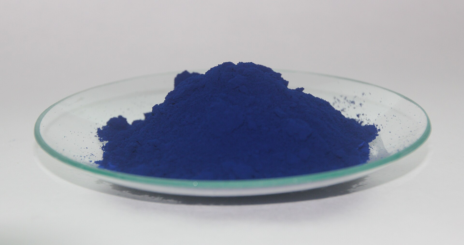 Prussian blue in powdered pigment form, on a watch glass.