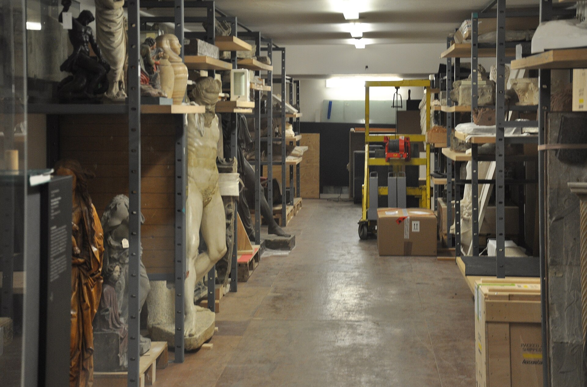 The closed store of the Liebieghaus, Frankfurt am Main, seen from the museum's open-storage gallery: sculpture on heavy-duty racking, crates and a pallet truck. Photographed April 2011.
