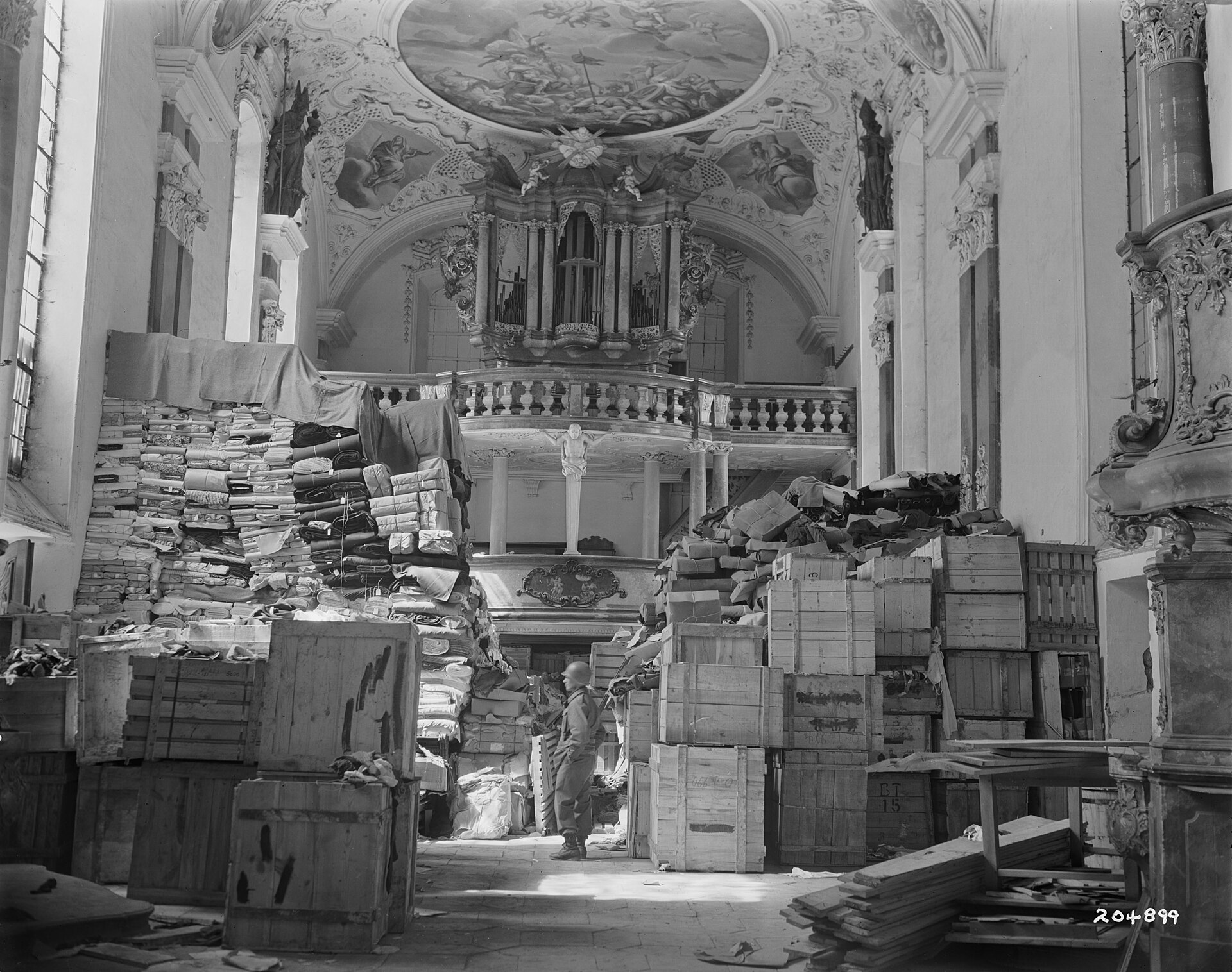 Looted art and archives stacked in the Schlosskirche at Ellingen, Bavaria, photographed by a US Army Signal Corps photographer on 24 April 1945 after the depot was found by troops of the Third Army.