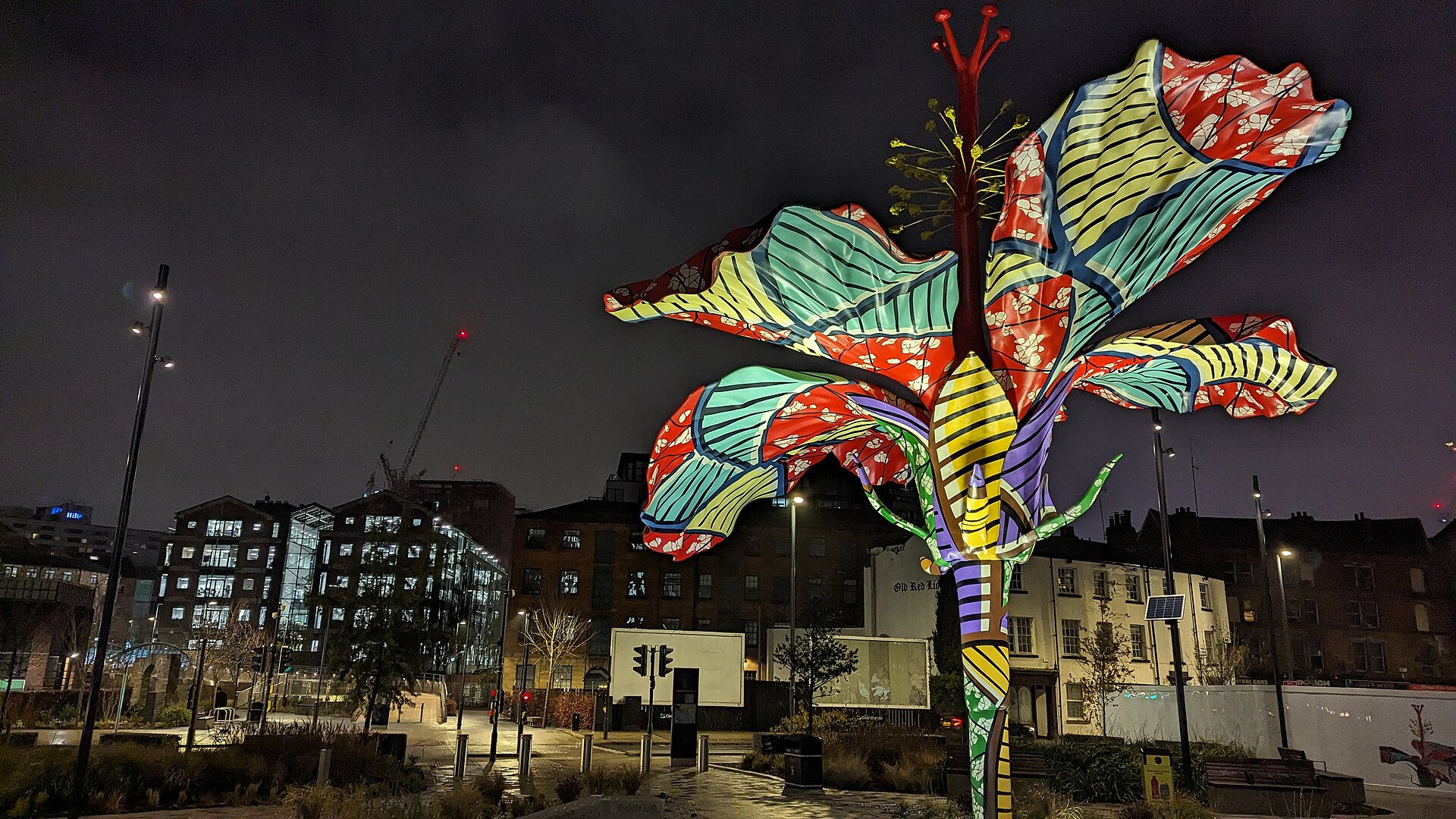 Hibiscus Rising (2023) at night, with the David Oluwale Bridge