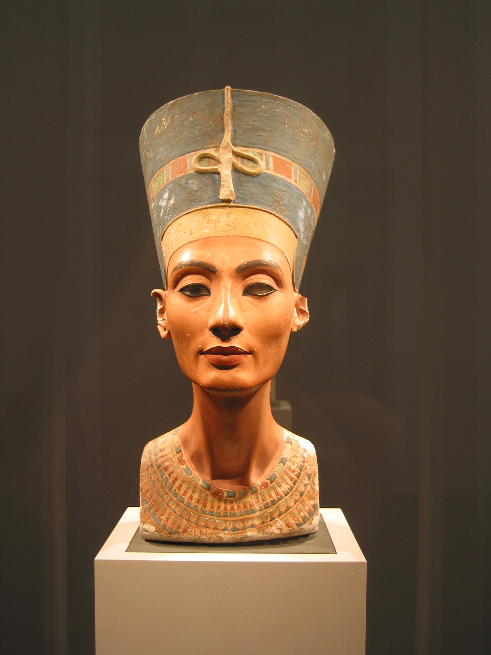 The bust of Nefertiti in the Neues Museum, Berlin, photographed from the front: the full painted crown, the inlaid right eye and the empty left socket. It was made about 1332 BCE, and the next thing recorded about it is 6 December 1912, the day it came out of the ground at Amarna. That is a first silence of 3,244 years, the longest in this archive, and the shape it takes is the ordinary shape of the corpus rather than the exception.