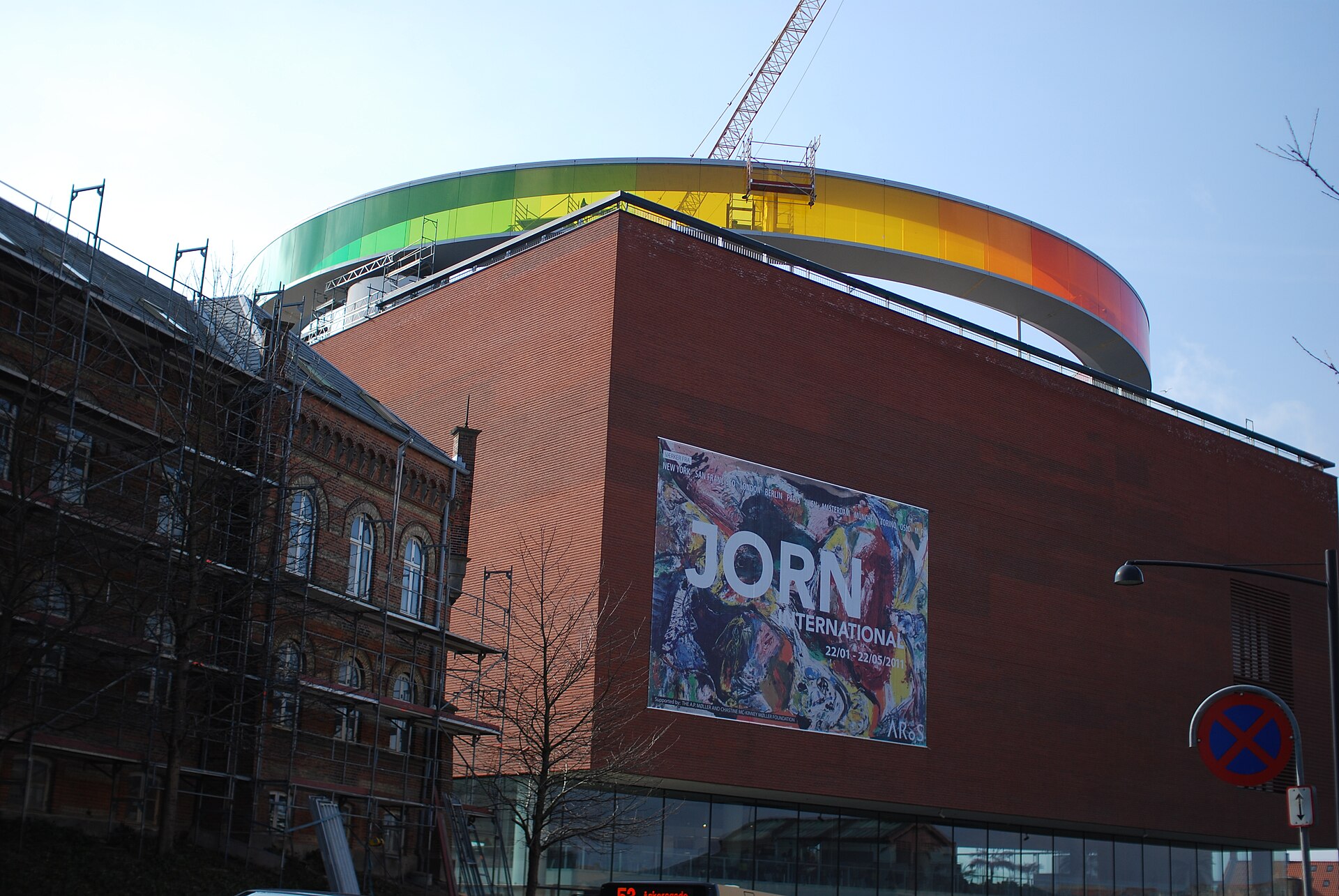 Visitors walking through the coloured glass corridor of Your Rainbow Panorama on the roof of ARoS