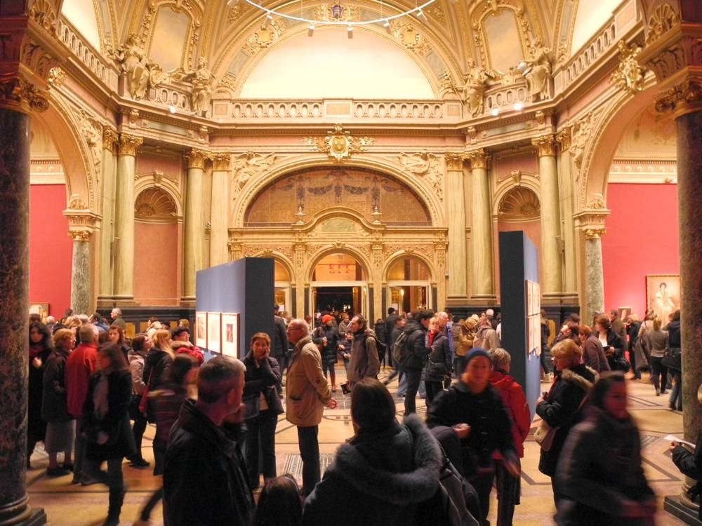 The main hall of the Art Pavilion during Zagreb's Night of Museums in 2012, its arched and gilded architecture visible above a crowd of visitors and a temporary exhibition installation