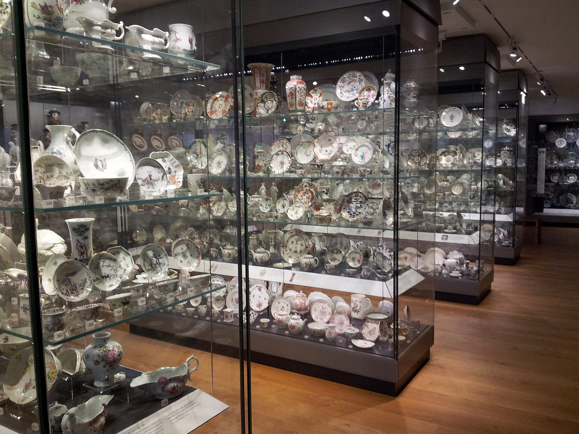A museum gallery of glass display cases filled with European porcelain and pottery