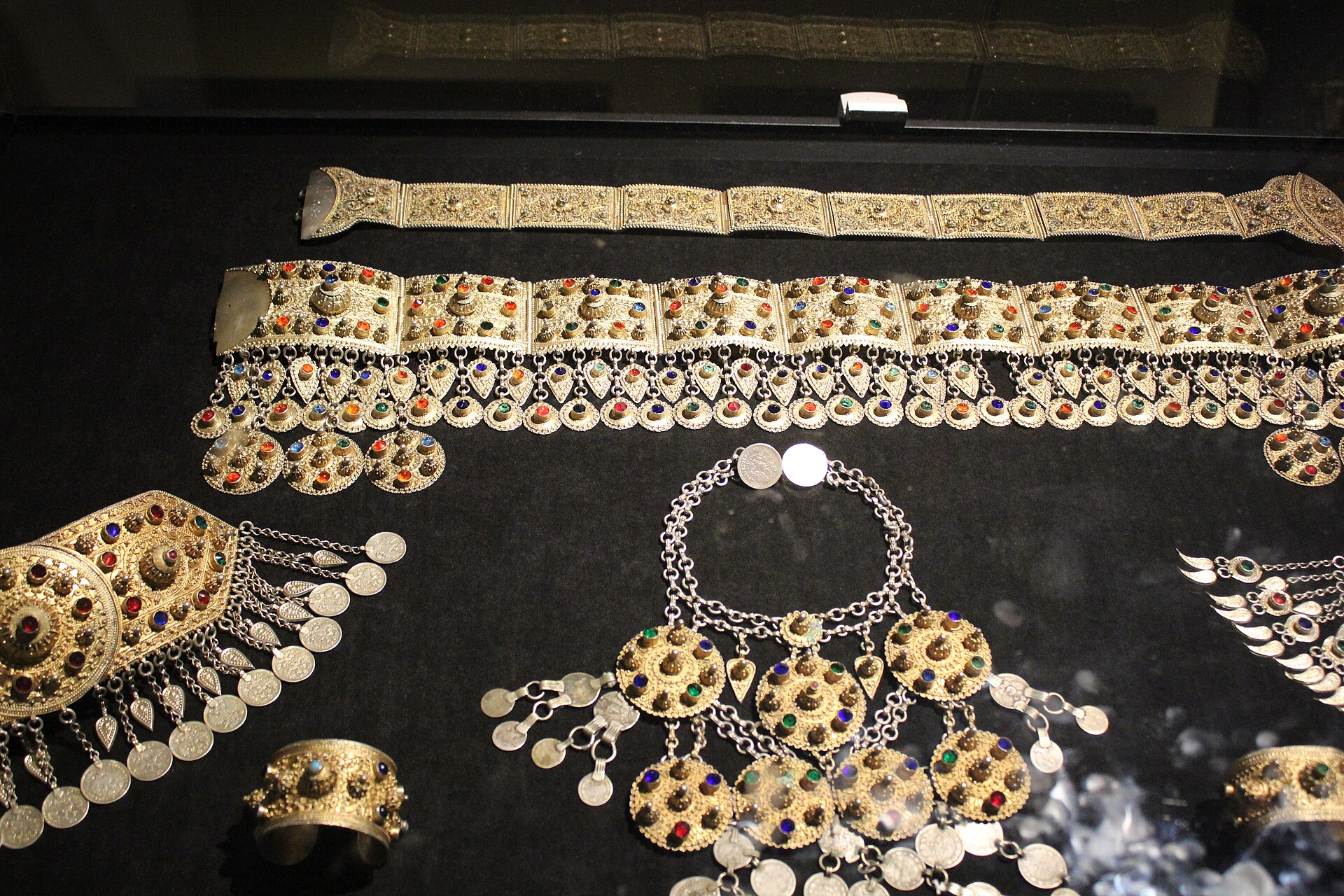 Silver and gilt Azerbaijani jewelry, belts and pendant ornaments in a display case