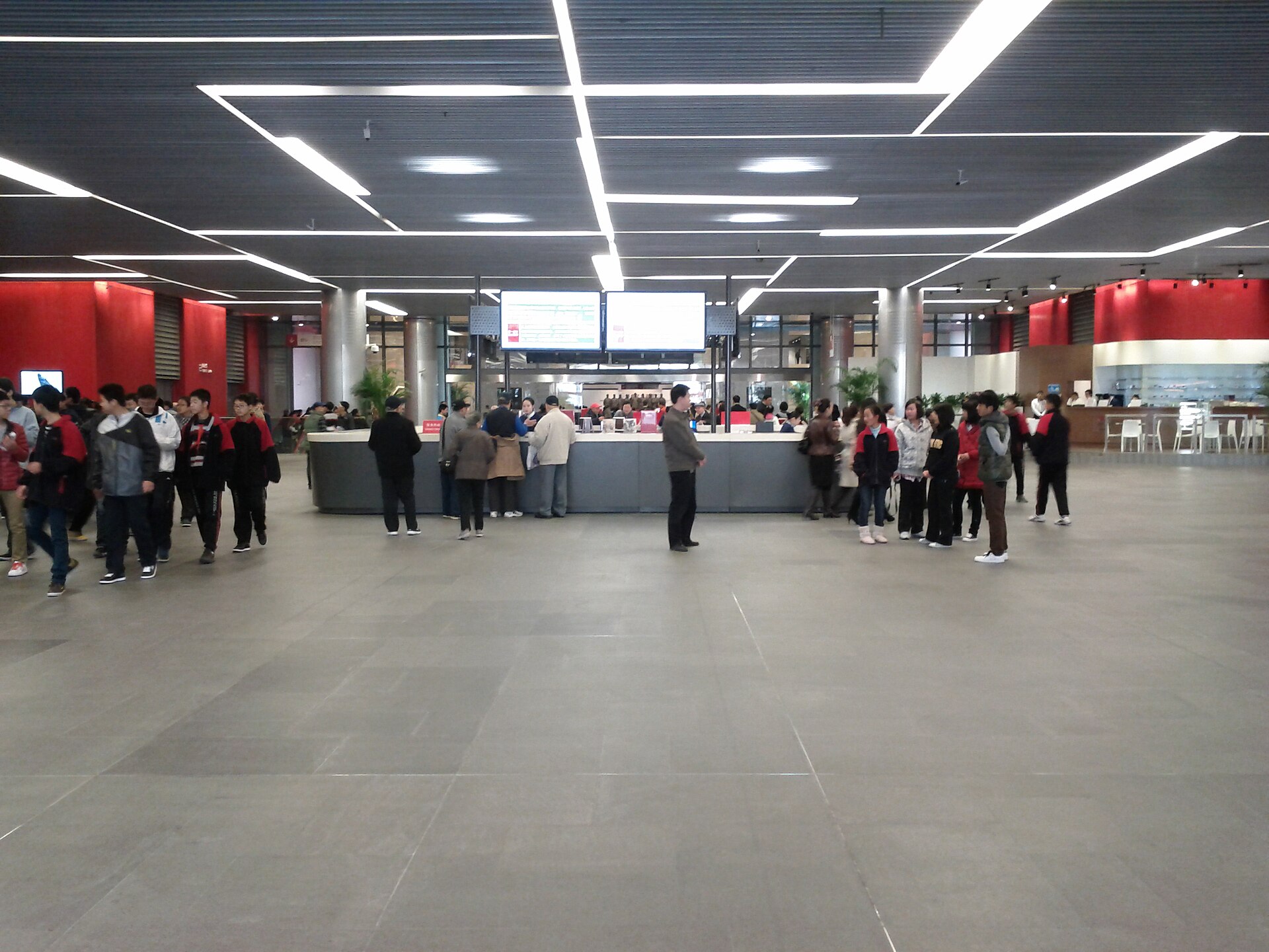 The ground-floor lobby of the China Art Museum, with visitors queuing at the information desk