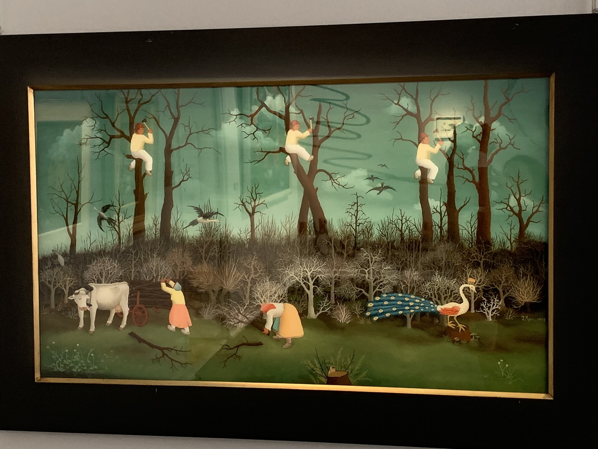 A wall of framed naive paintings on display inside the museum