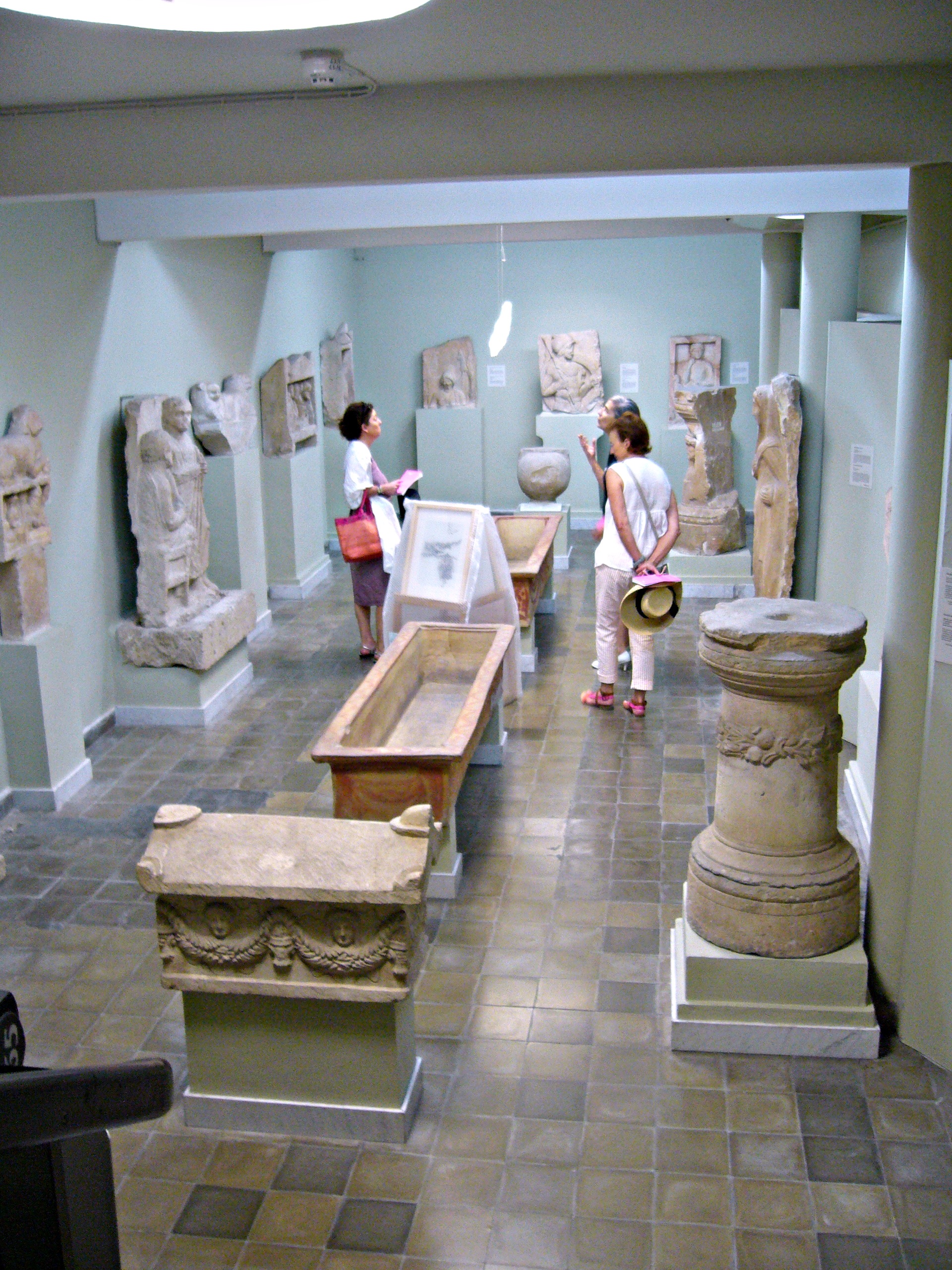 Room 9 of the Cyprus Museum, with carved grave stelae and painted clay sarcophagi