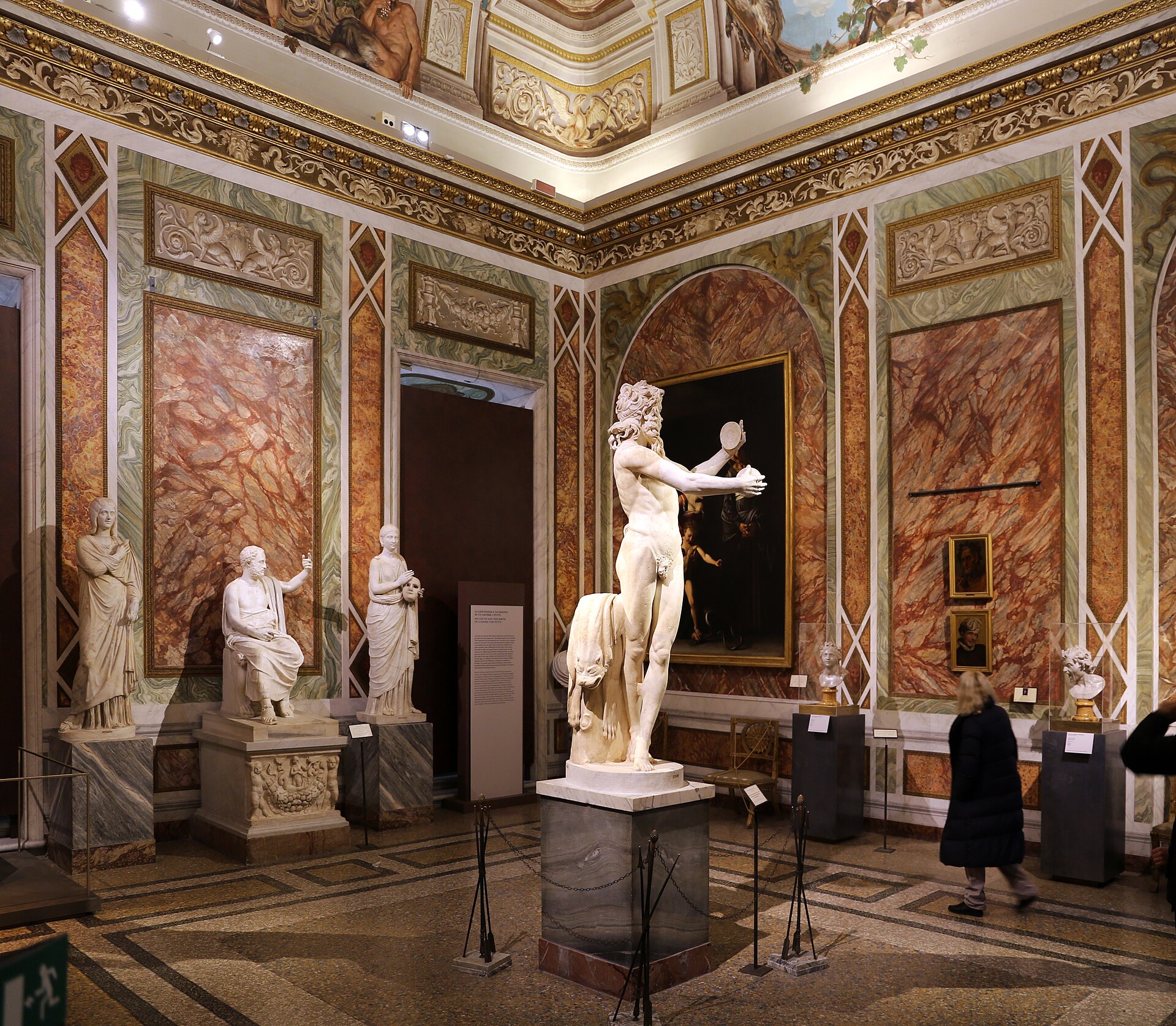 The Silenus Room, with the restored Dancing Satyr and a Caravaggio painting on the wall behind it