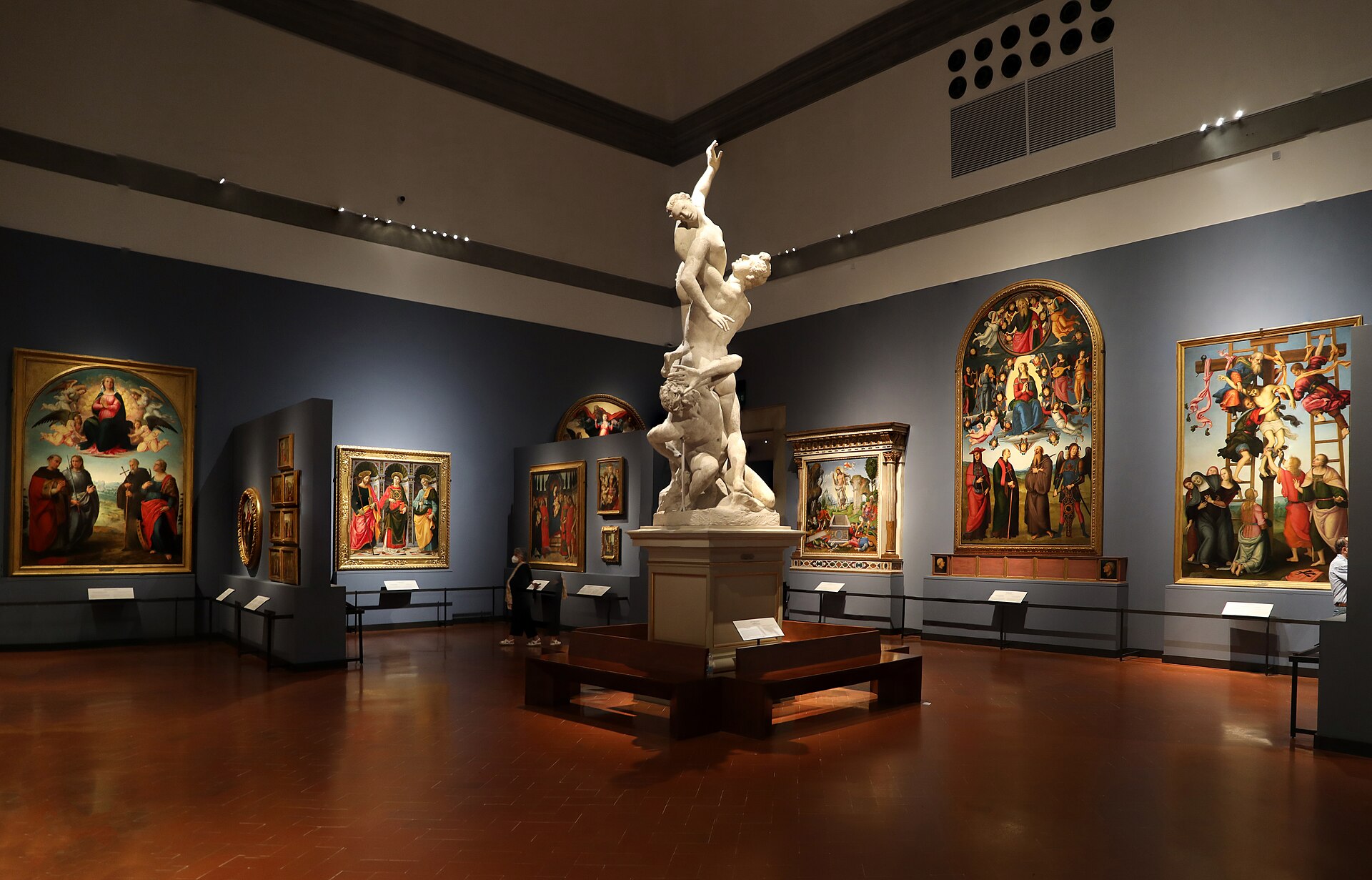 The Sala del Colosso, with Giambologna's full-scale clay model for the Rape of the Sabine Women at the centre and gold-ground Renaissance panel paintings on the surrounding walls