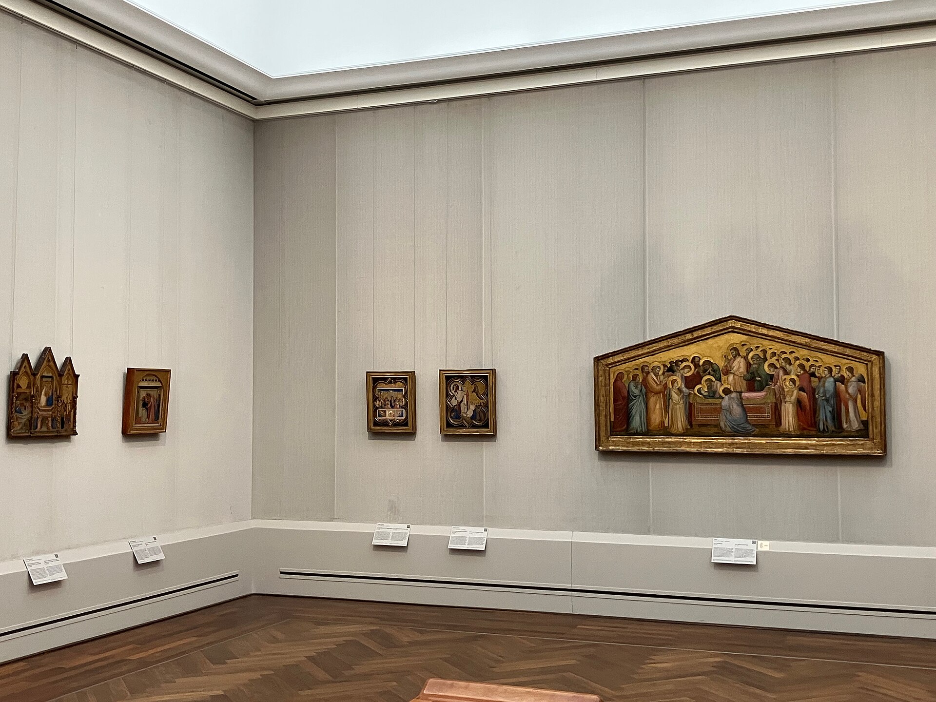 An Italian cabinet with small gold-ground panels and a large gabled trecento panel