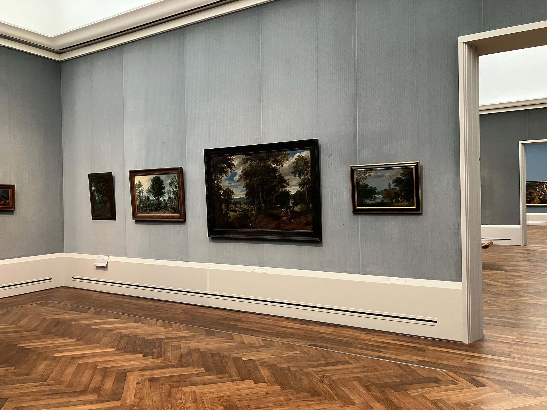 A cabinet of seventeenth-century Netherlandish landscape painting on a grey-blue fabric wall