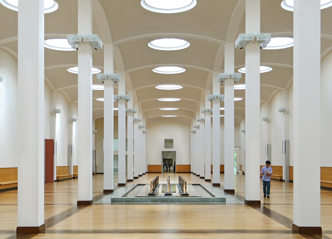 The columned central hall with its barrel vault, circular skylights and the water basin at the centre