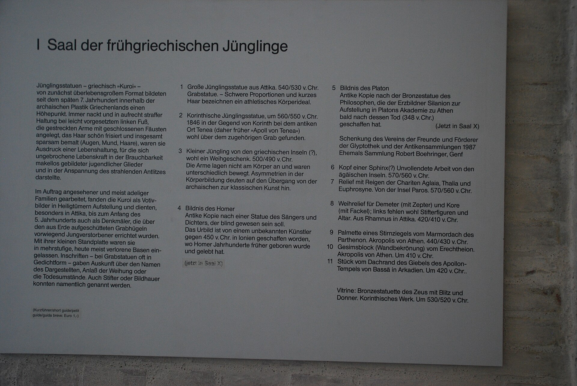 The museum's own wall panel for Room I, in German, listing the archaic kouroi on display and their approximate dates