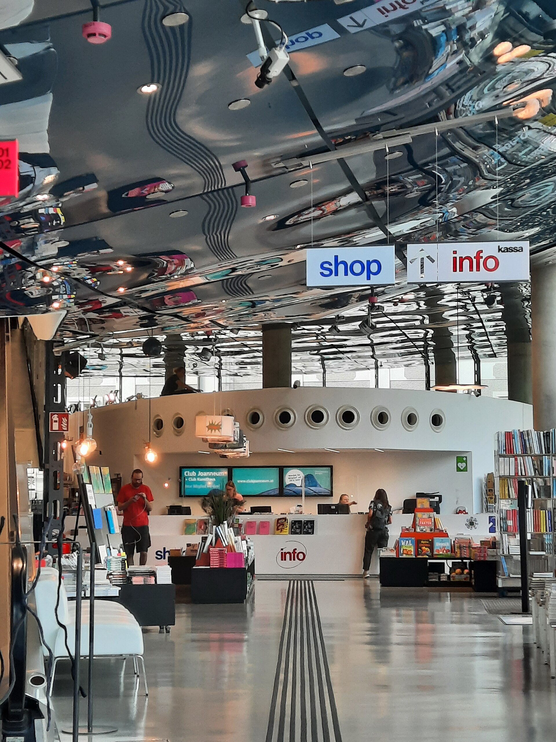 The Kunsthaus Graz entrance hall, with the shop and information desk beneath the mirrored underside of the biomorphic shell