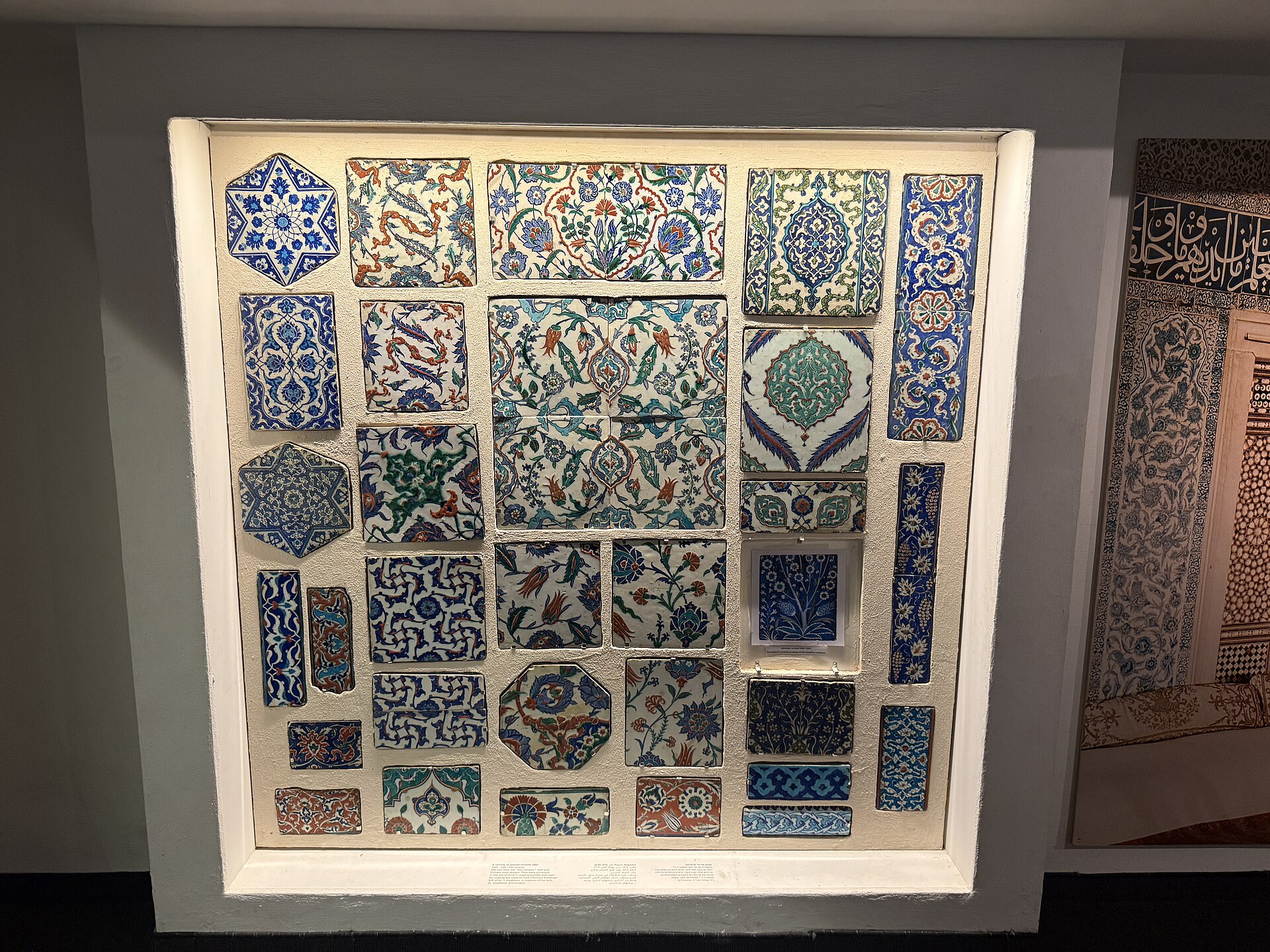 A wall-mounted case of Ottoman-period ceramic tile fragments in blue, green and red glaze