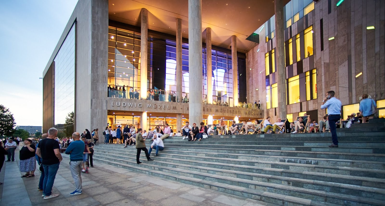 Visitors on the Ludwig Museum's riverside terrace at dusk during Museum Night 2019