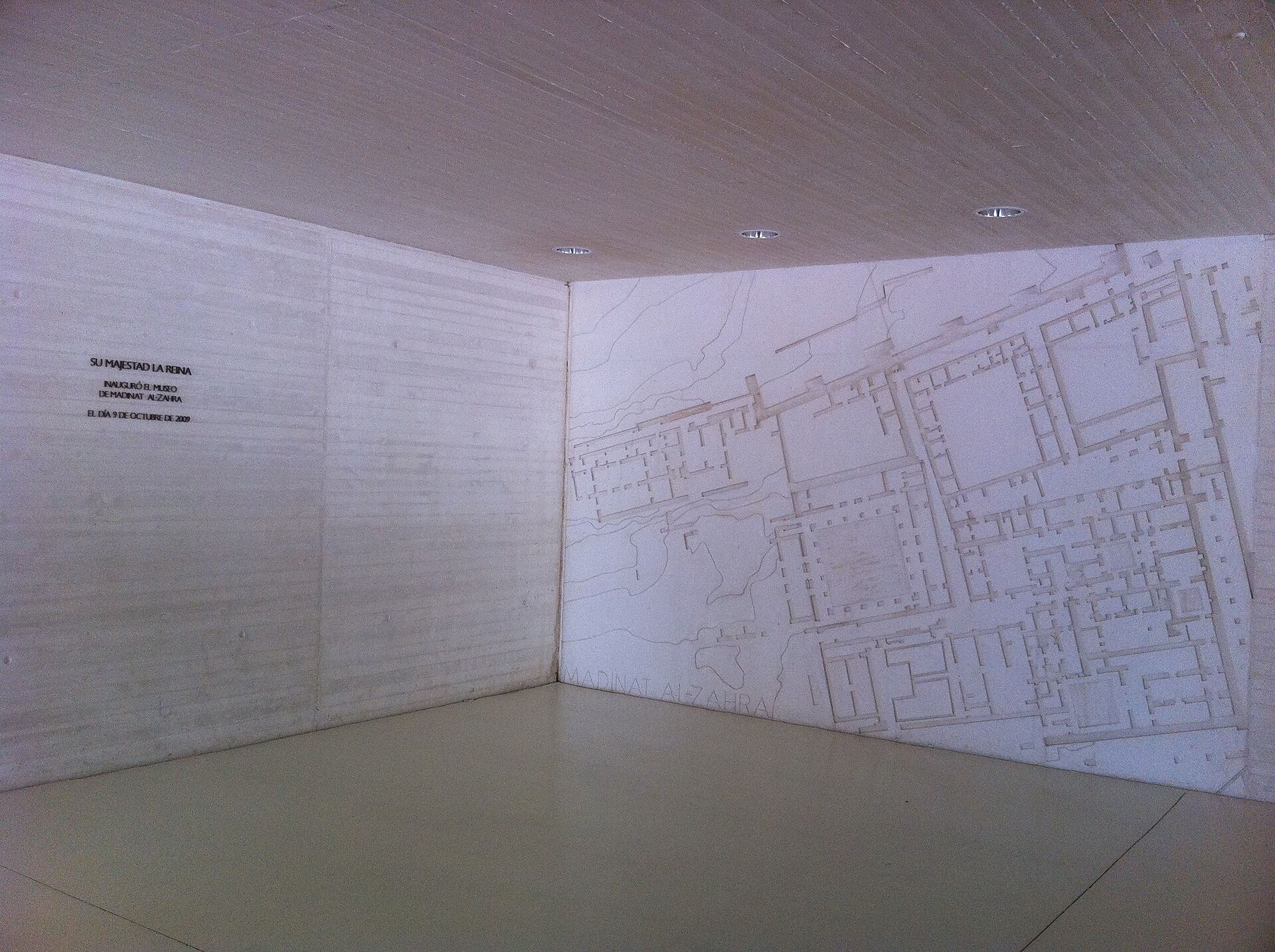 Entrance hall wall engraved with the plan of Madinat al-Zahra, beside a plaque recording the museum's 2009 inauguration