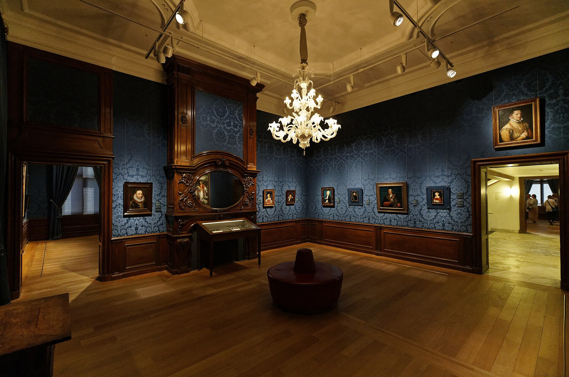 A hung room in the historic building, with its carved chimneypiece and chandelier