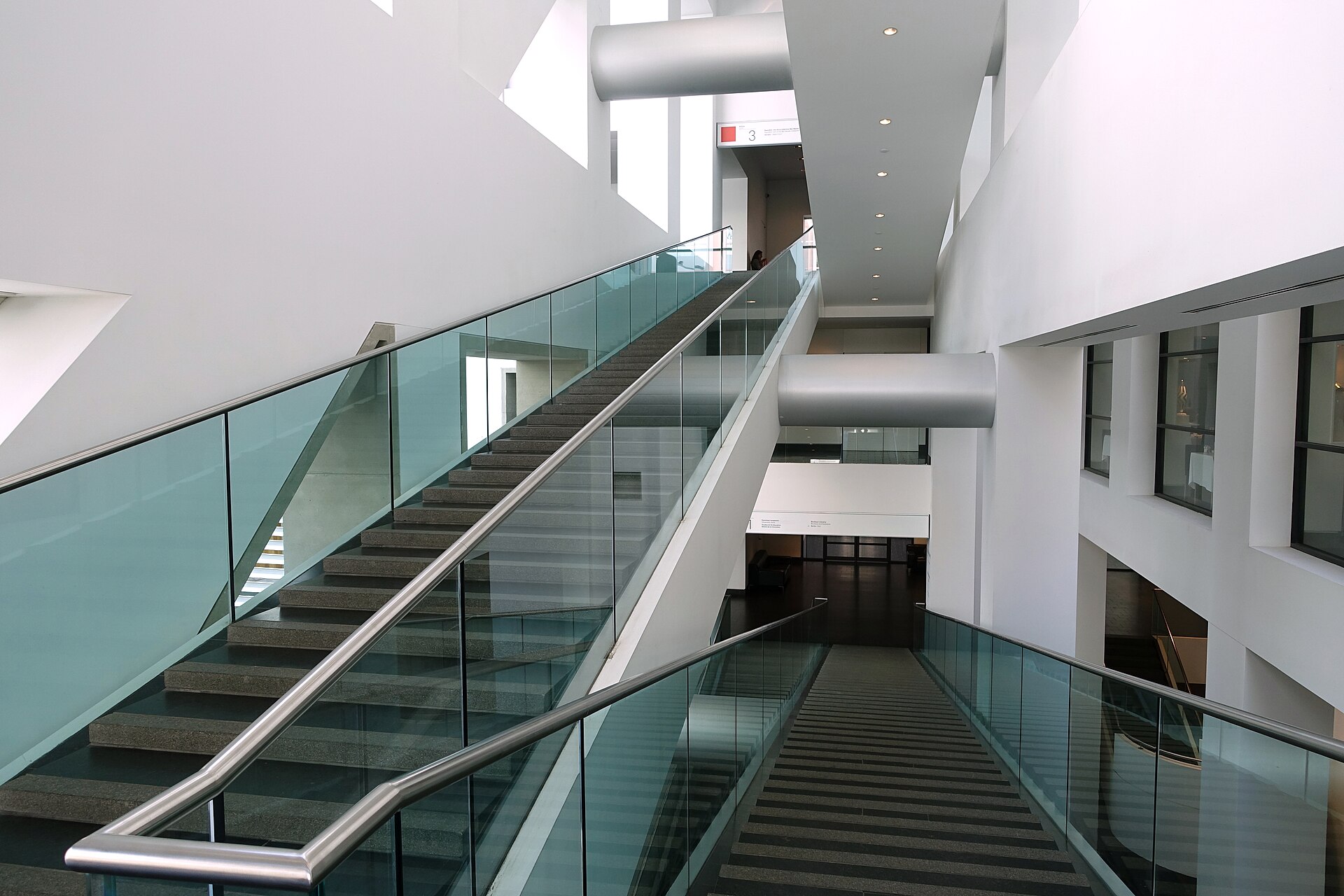 The angled glass and concrete staircase inside the Jean-Noel Desmarais Pavilion