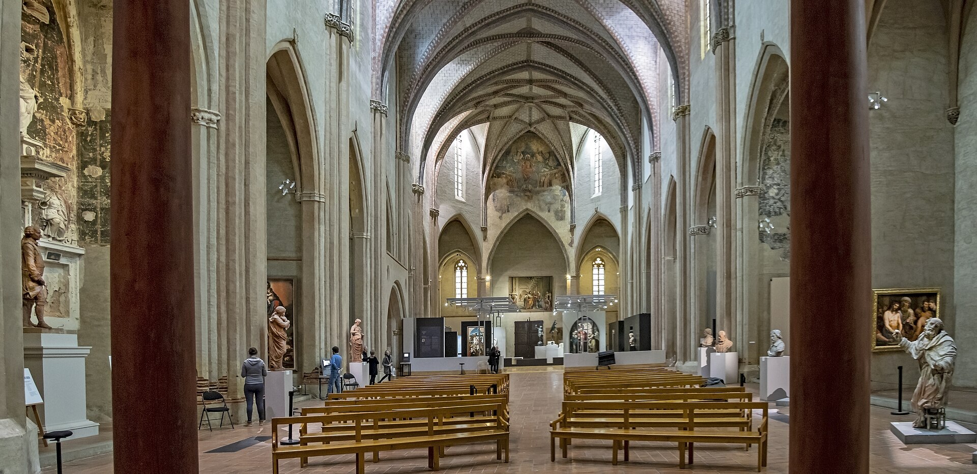 The vaulted gothic nave of the former convent church, used as a gallery, with sculptures on plinths and framed paintings between the pillars, photographed before the museum's current closure of the space.