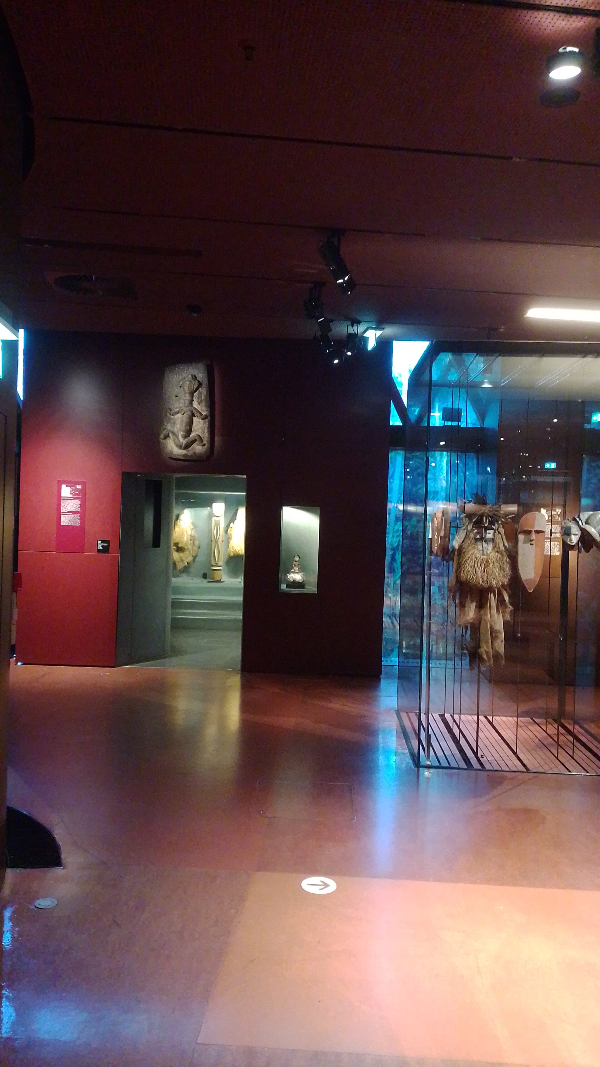 Masks and figures displayed in glass cases in the museum's Africa gallery