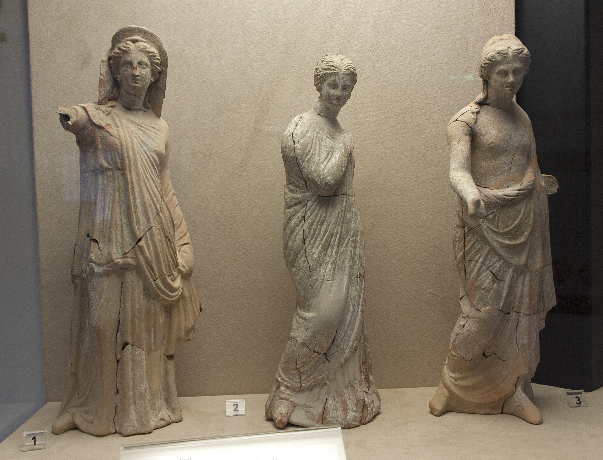 Three Hellenistic-period statues from Morgantina displayed together at the Museo Archeologico di Aidone, including a statuette of Persephone