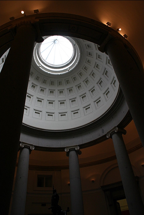 Looking up into a coffered dome with a glazed oculus, framed by tall Ionic columns