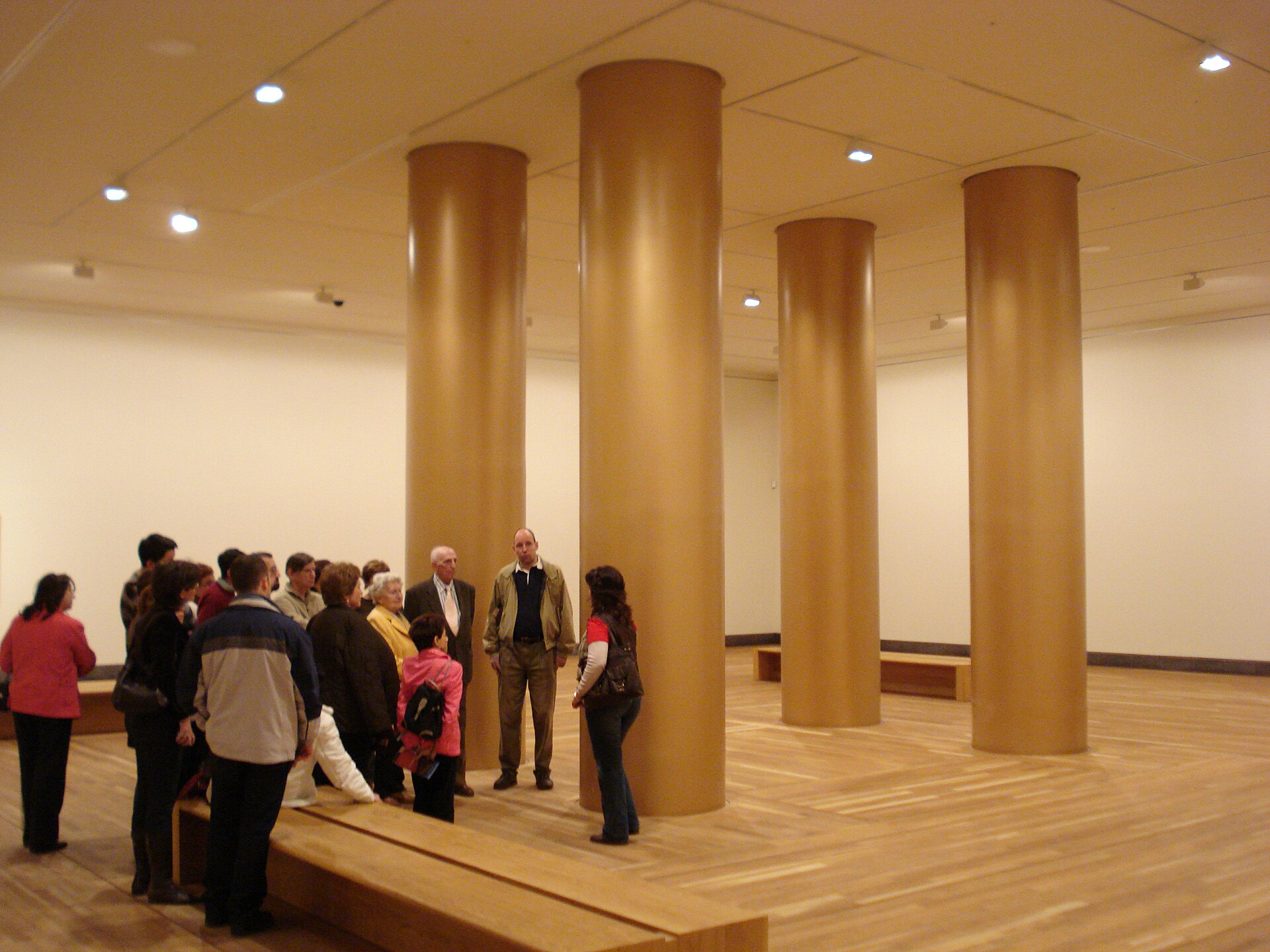 A newly finished gallery in the extension with four broad ochre columns, oak parquet and long timber benches