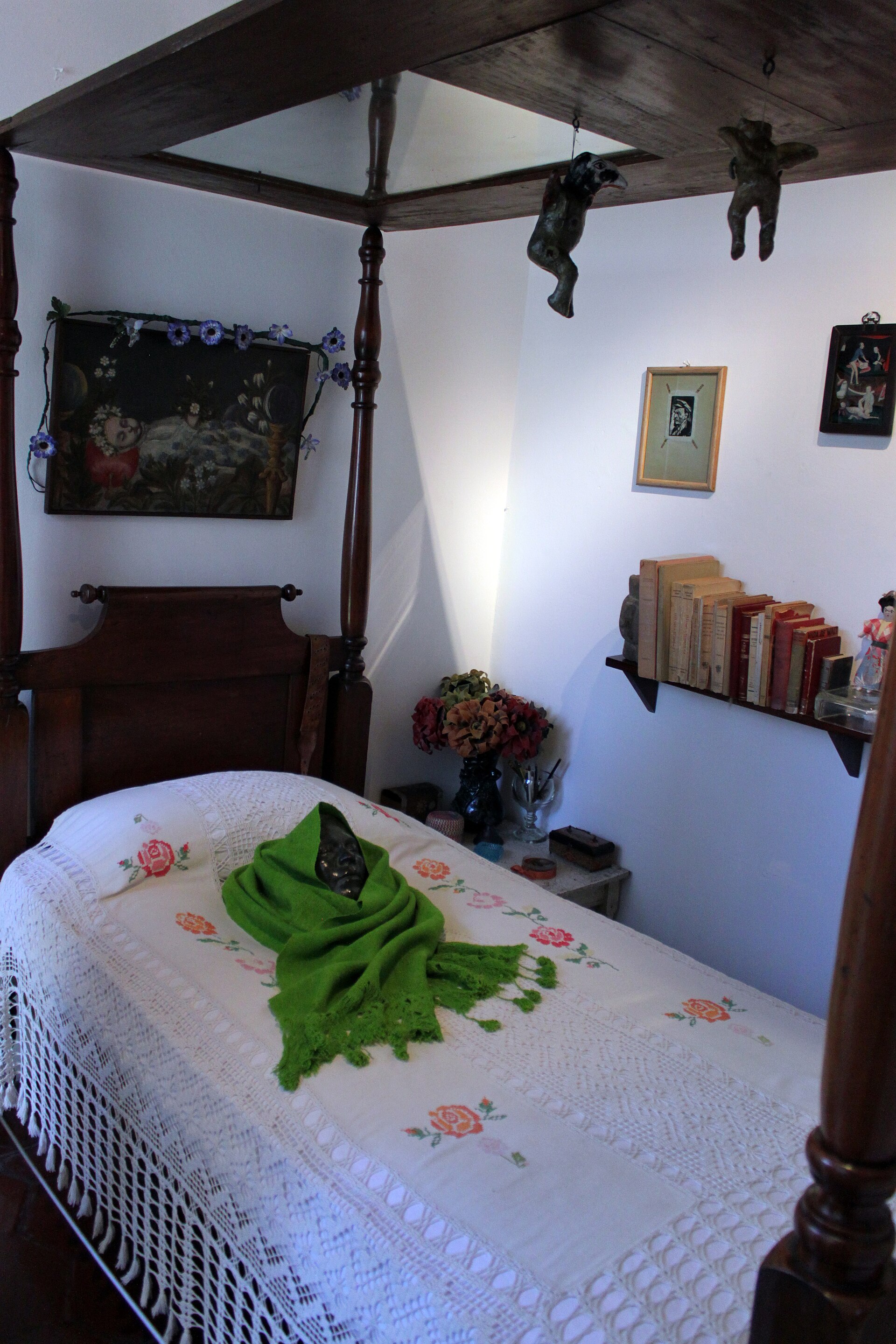 Frida Kahlo's bed with a mirror in the canopy and a death mask, in her bedroom at the Frida Kahlo Museum