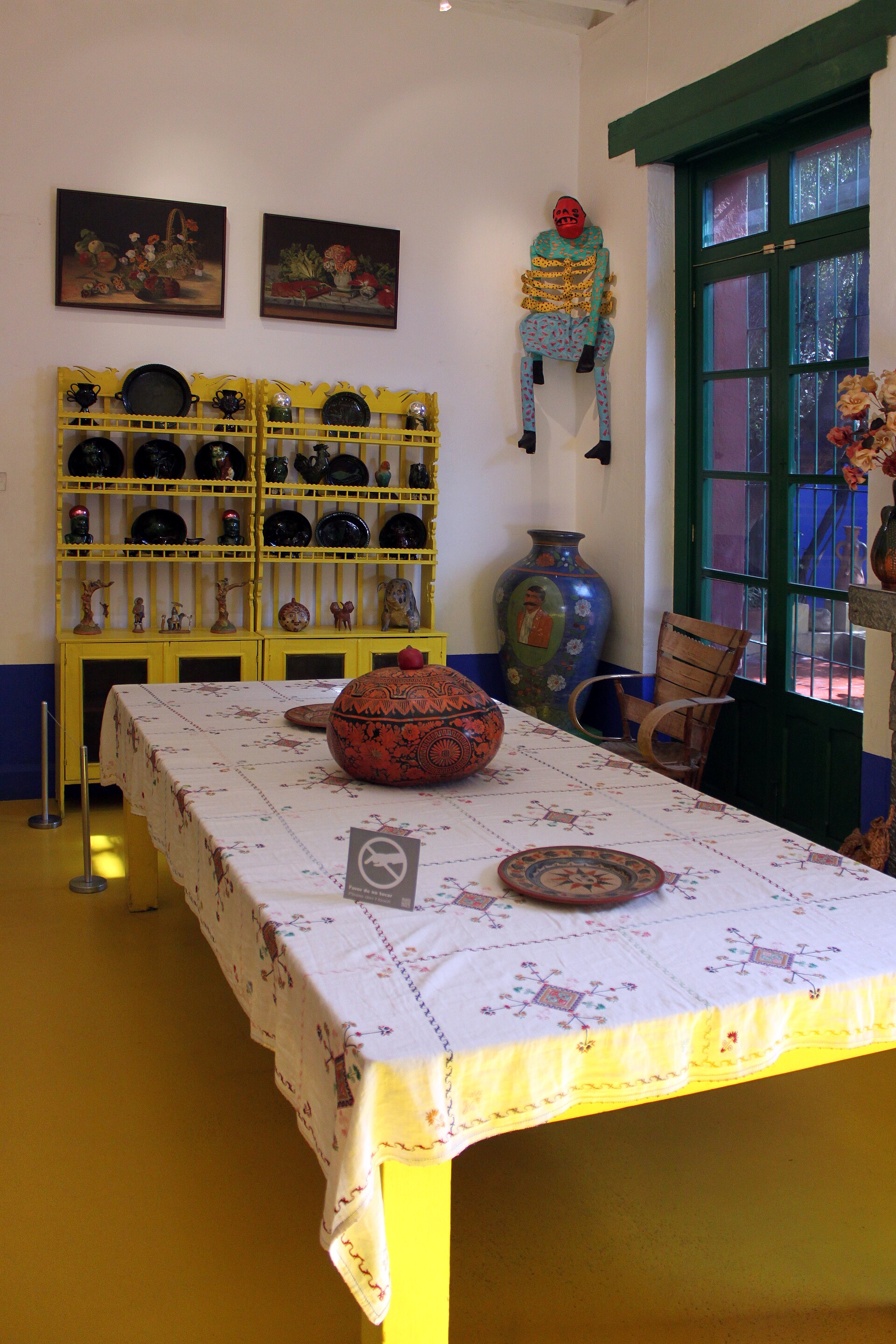 The dining room of the Frida Kahlo Museum with papier-mache Judas figures hanging from the ceiling
