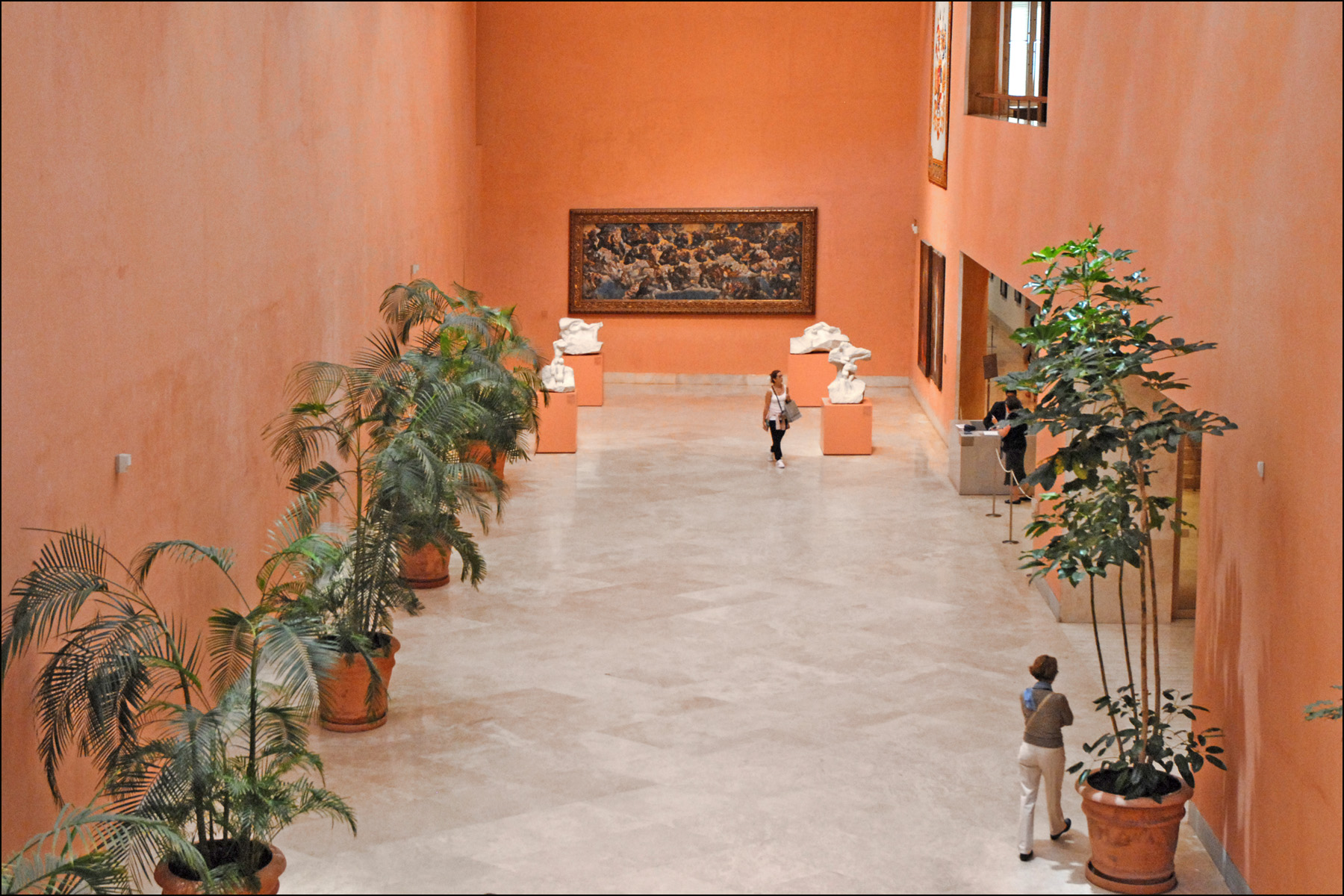 The terracotta-walled entrance hall, with white marble Rodin sculptures on plinths and a large old-master painting on the end wall