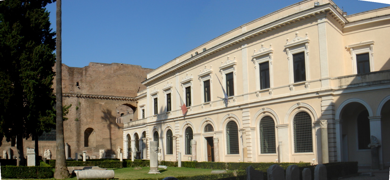 The historic entrance to the Baths of Diocletian site, with the ancient Roman bath ruins visible behind the 19th-century entrance building