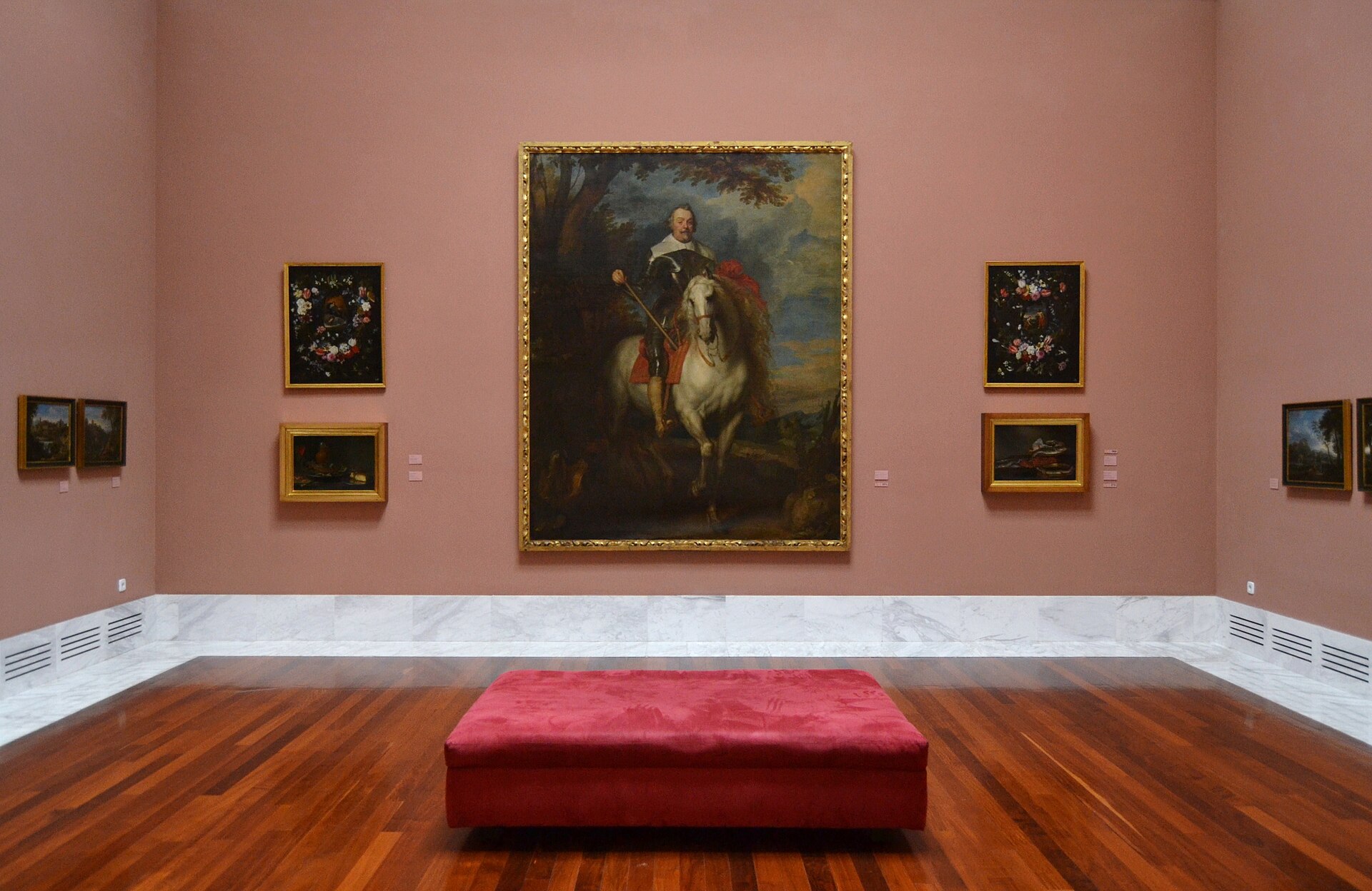 A gallery hung with Flemish and Baroque paintings, including a large equestrian portrait flanked by smaller works, in the museum's permanent collection rooms