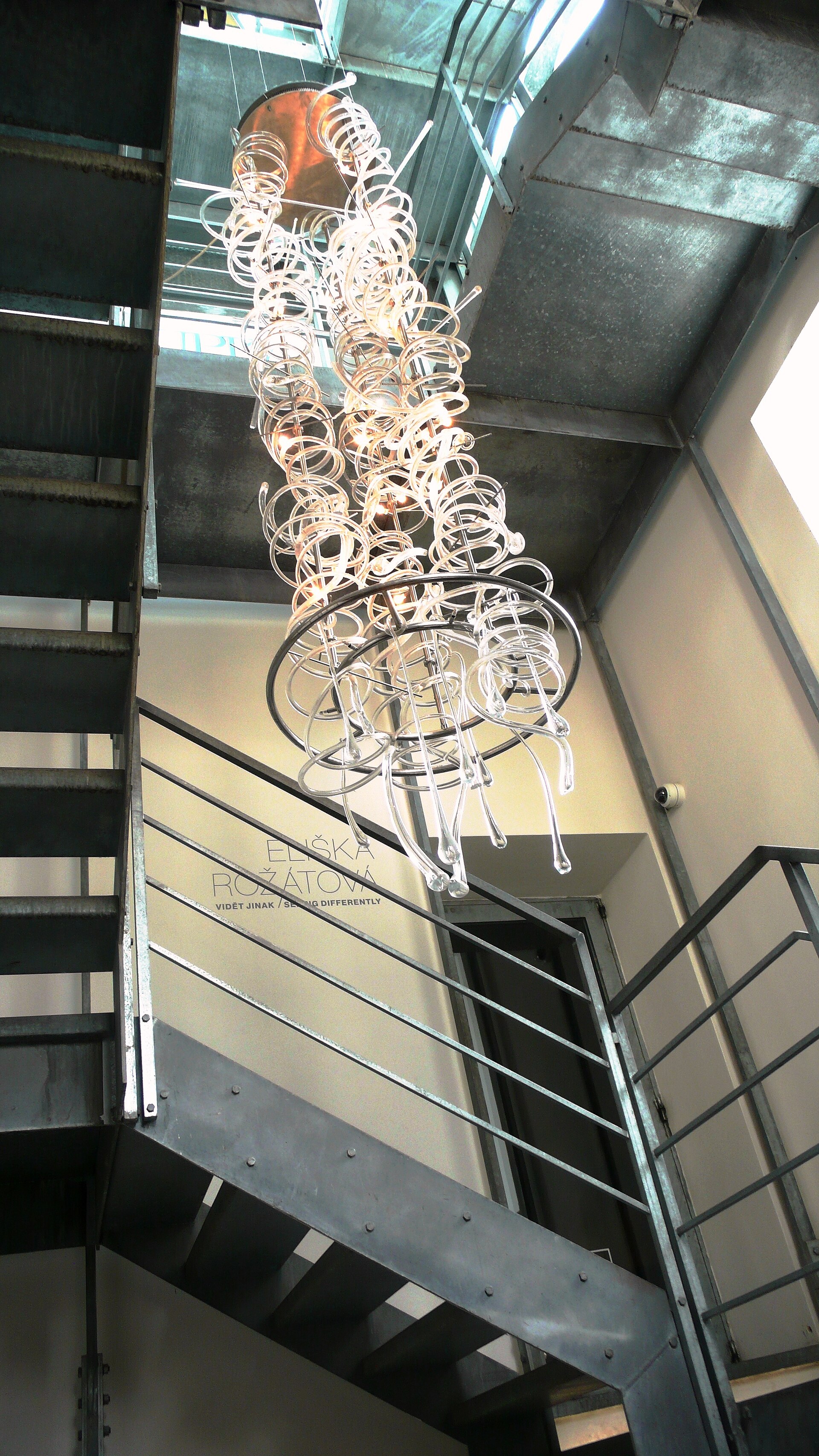 Interior glazed stairwell with a chandelier inside Museum Kampa