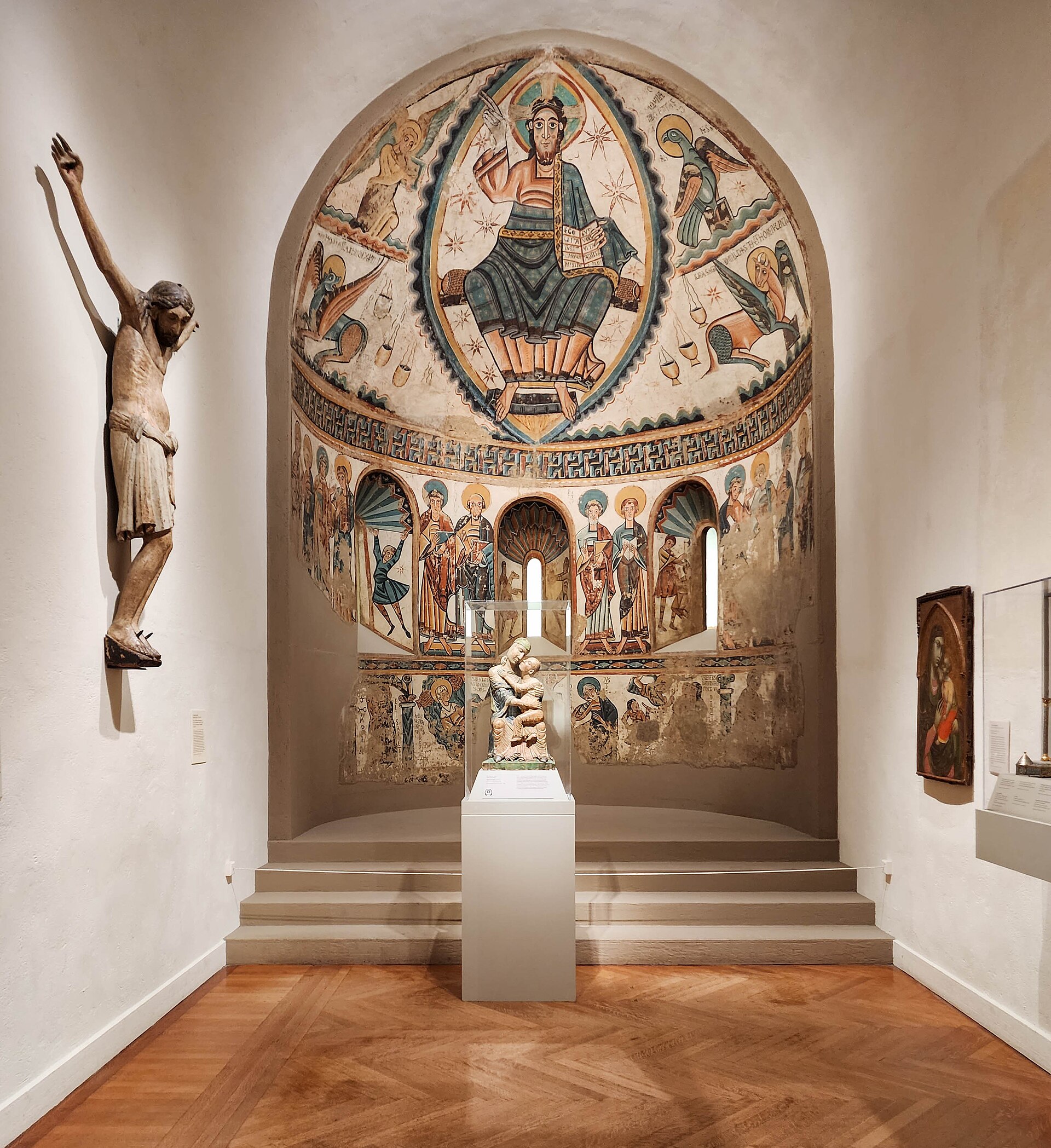 A gallery of medieval European art, with a reconstructed painted Romanesque apse and a carved wooden crucifix