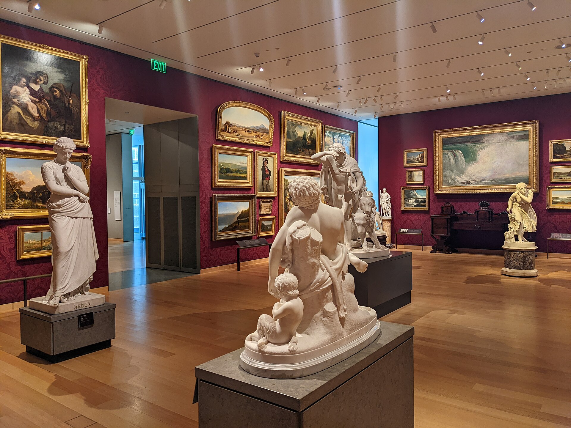A red-walled American sculpture and painting gallery, with William Wetmore Story's Medea in the foreground