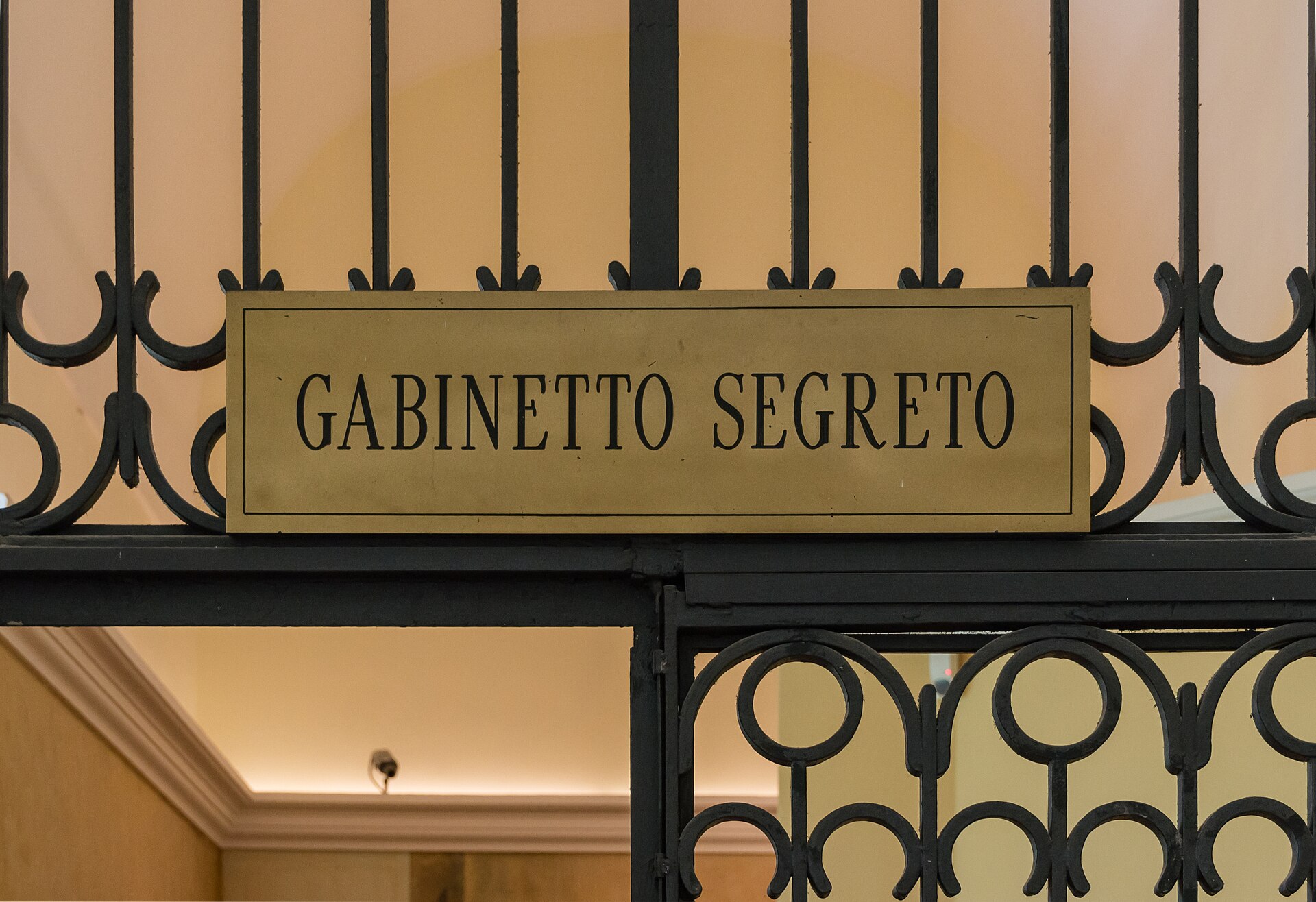 The wrought-iron gate and brass sign reading GABINETTO SEGRETO at the entrance to the room