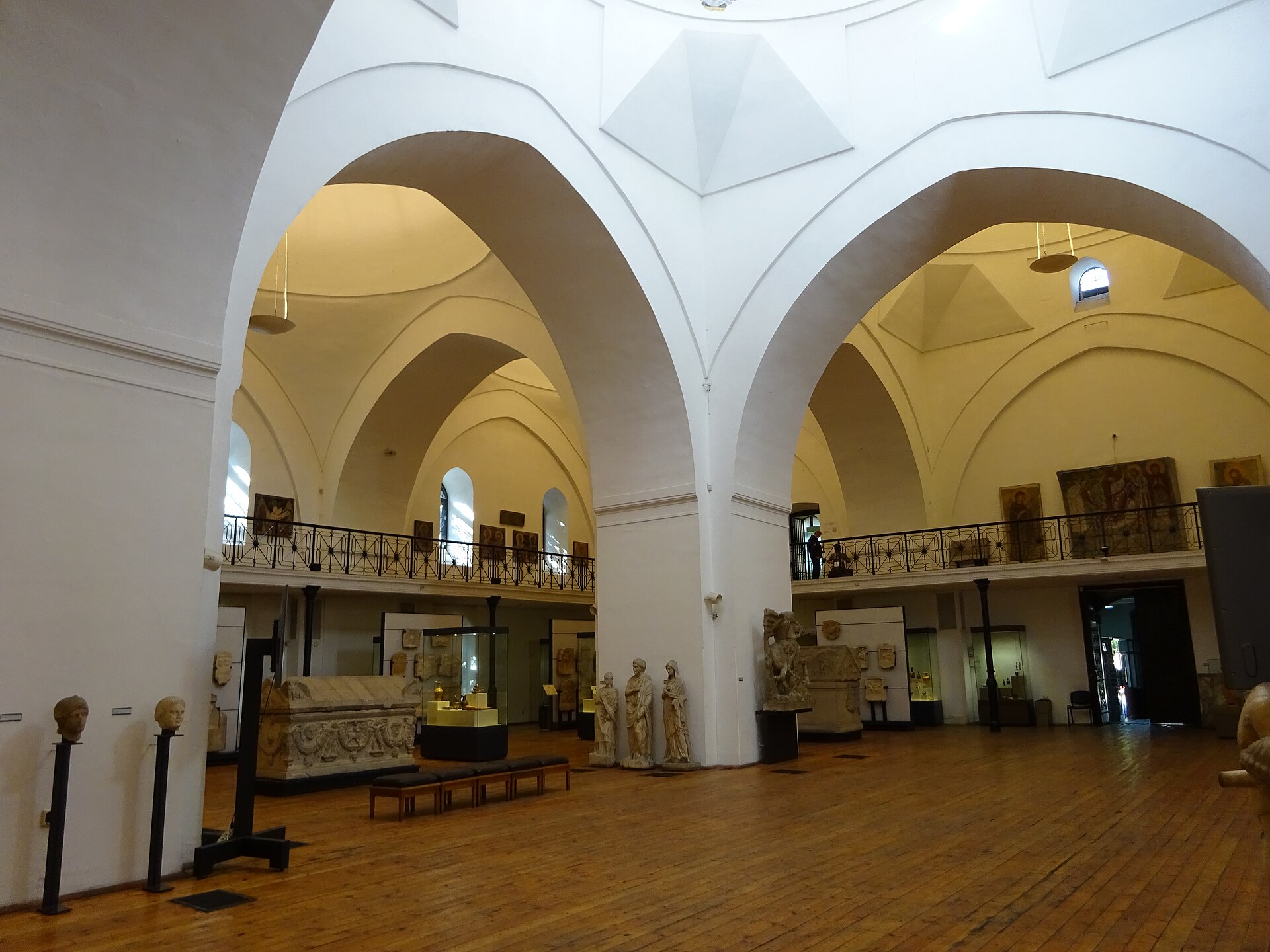 Marble statues, a carved sarcophagus and Roman busts arranged on the ground floor of the Central Hall, seen beneath the vaulted arches of the former mosque