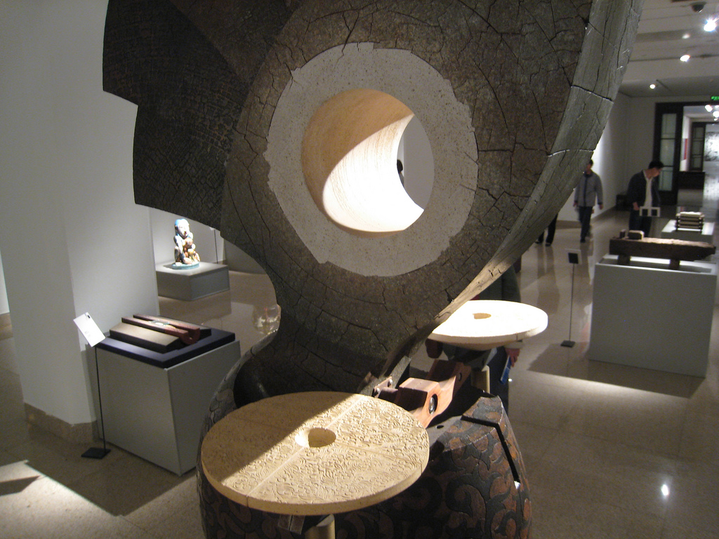 A large carved wood and stone sculptural installation on display inside the National Art Museum of China