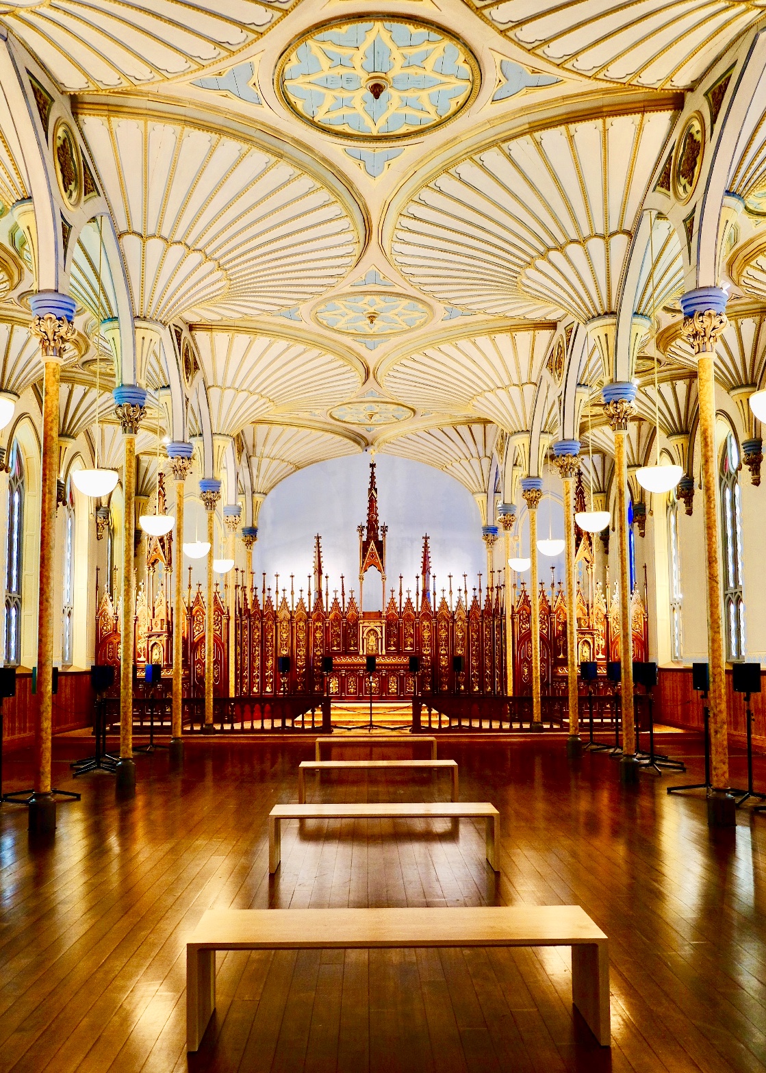 The gilded, fan-vaulted interior of the Rideau Street Chapel, looking down the nave toward a red-and-gold altar