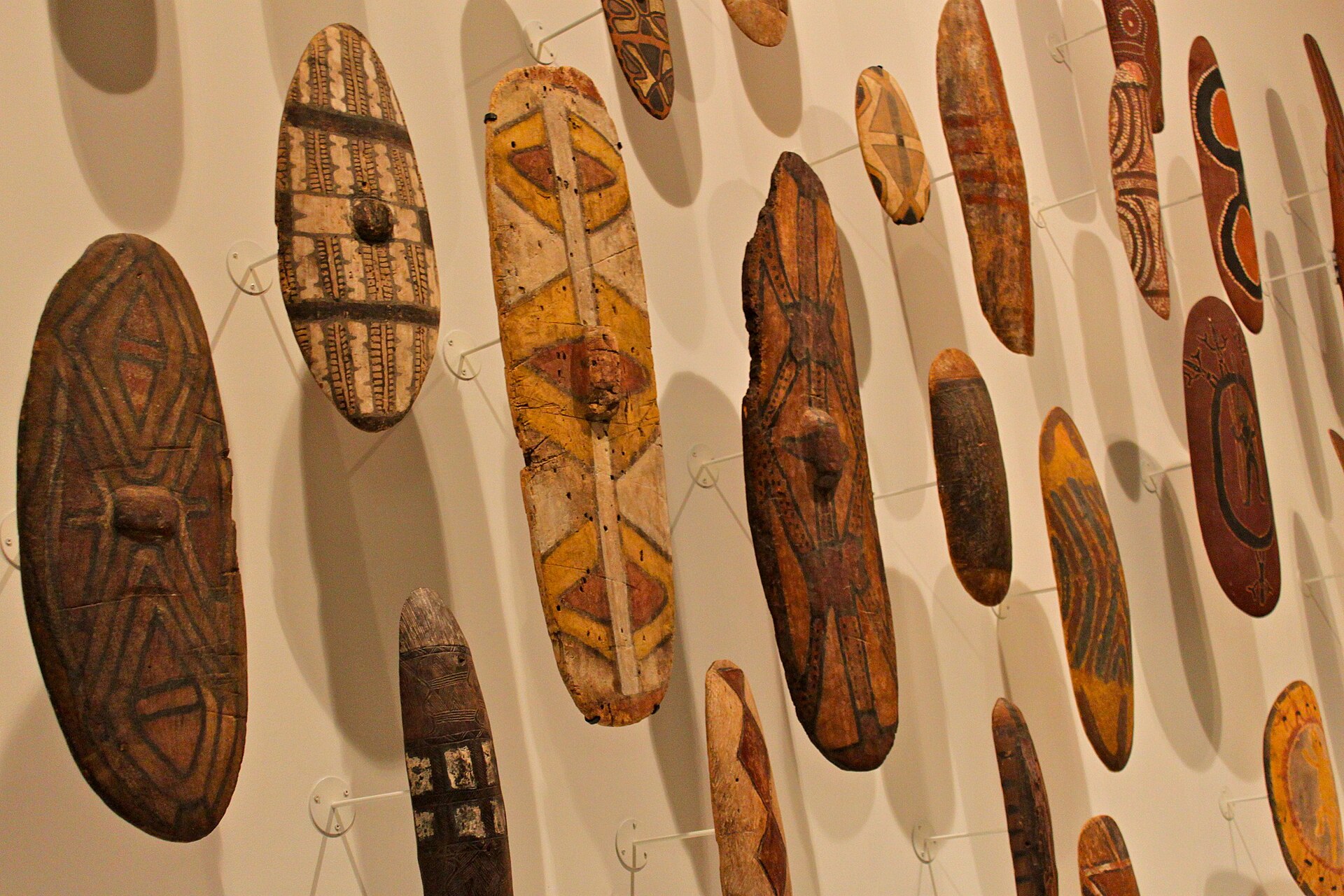 A wall of painted wooden shields on display at The Ian Potter Centre