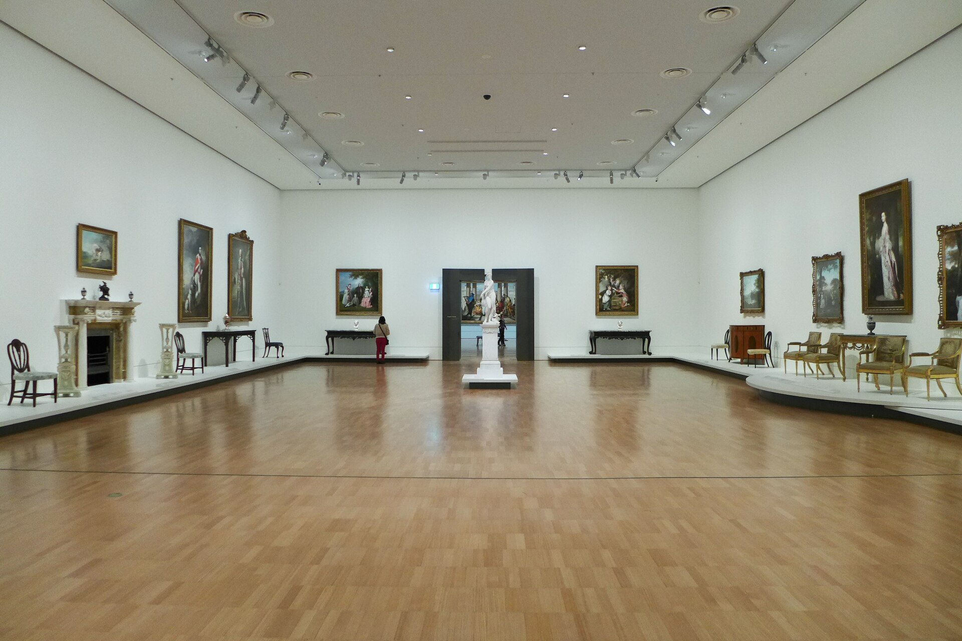 A period-hung gallery of 18th-century British and European portraits with furniture set against the walls