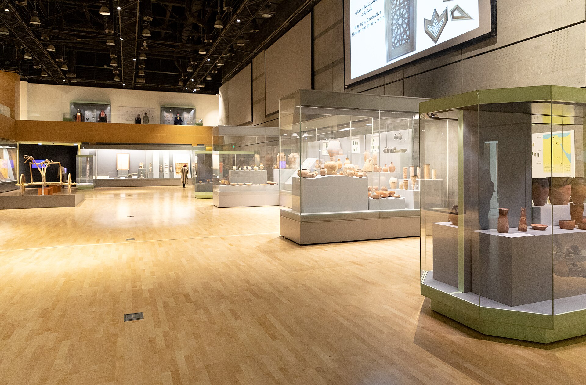 Display cases of pottery and small objects in the Main Gallery of the National Museum of Egyptian Civilization