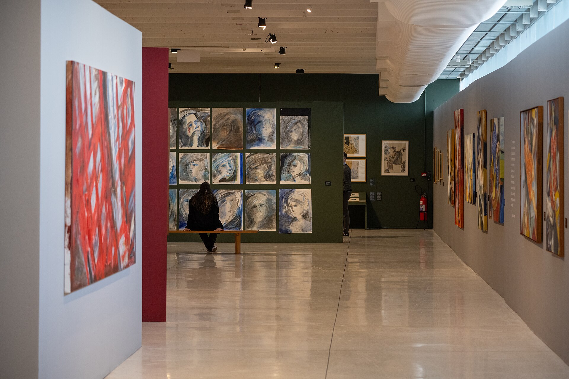 A partitioned exhibition gallery inside the Oscar Niemeyer Museum, hung with contemporary paintings