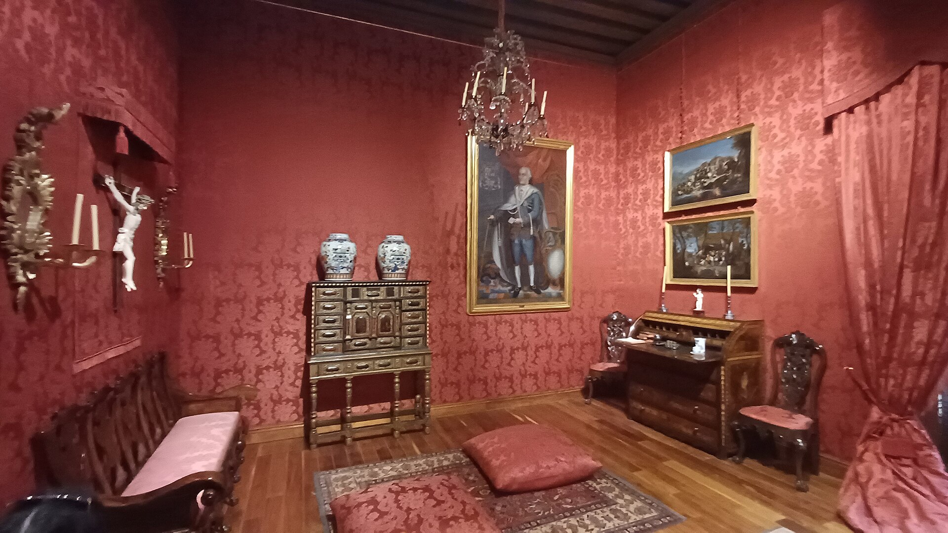 A furnished period room with a portrait, a secretaire desk and blue-and-white porcelain jars
