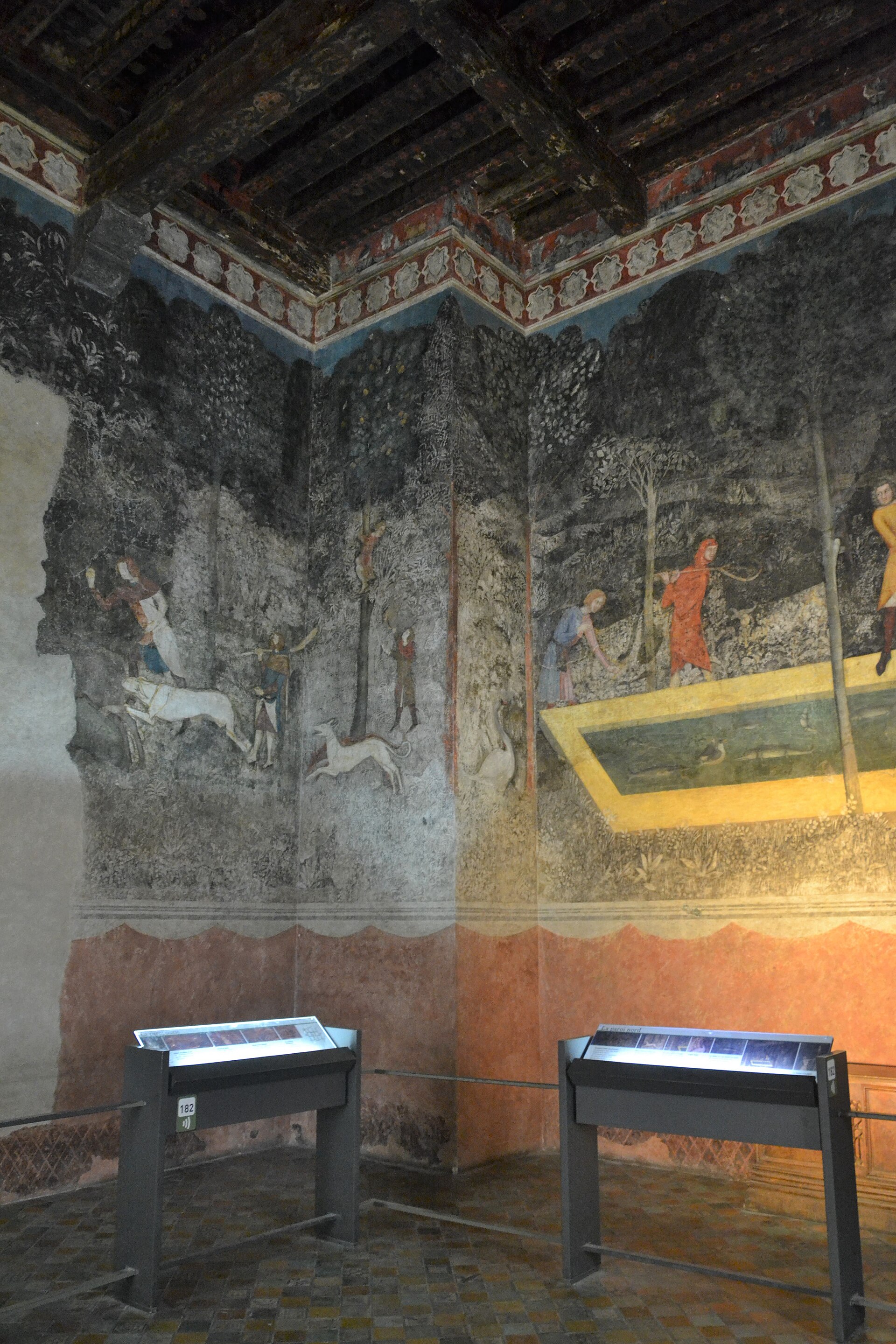 The Chambre du Cerf, its walls covered floor to ceiling with painted hunting and fishing scenes set in a forest landscape