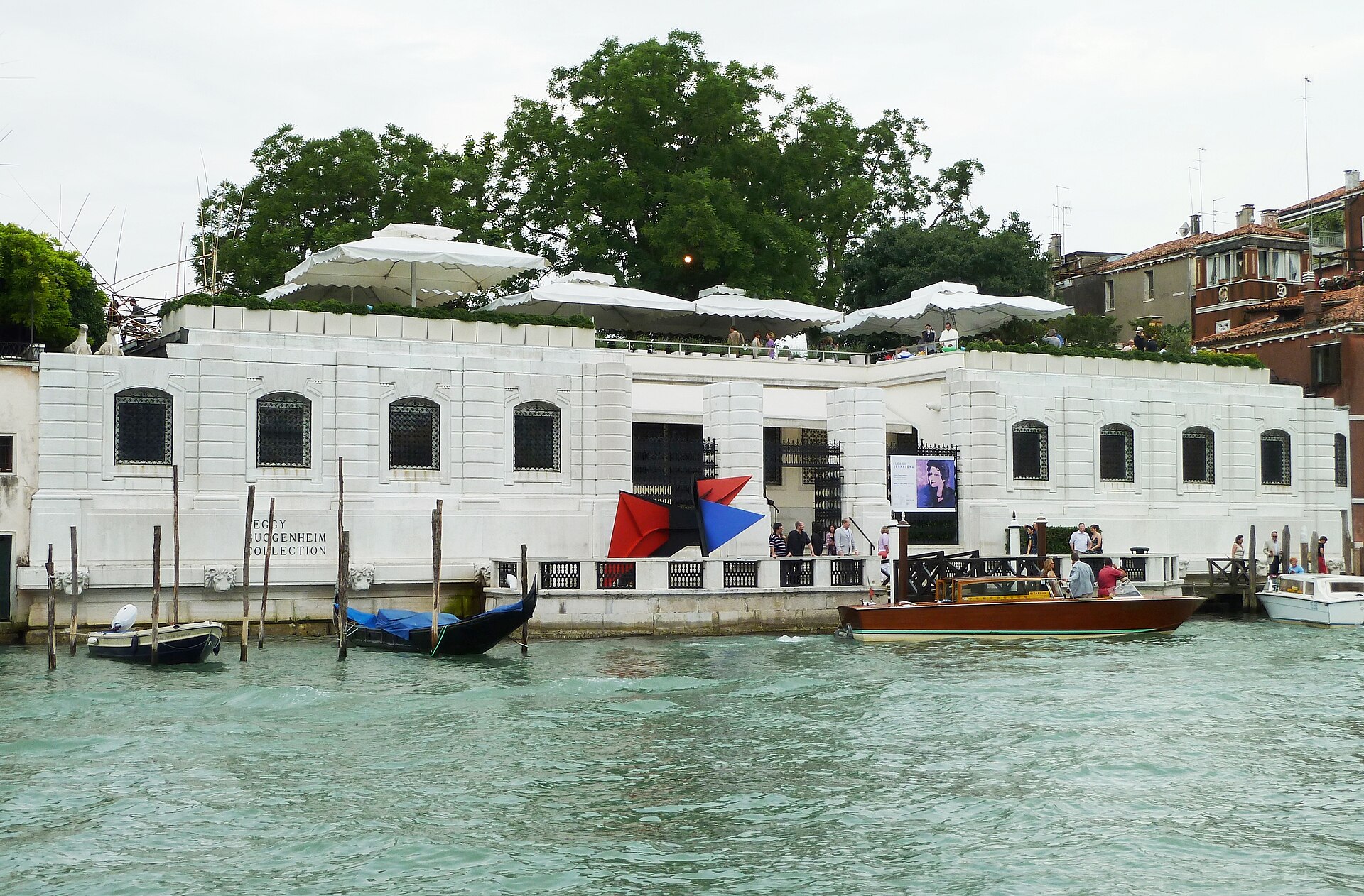 The facade from the water, with a passing boat