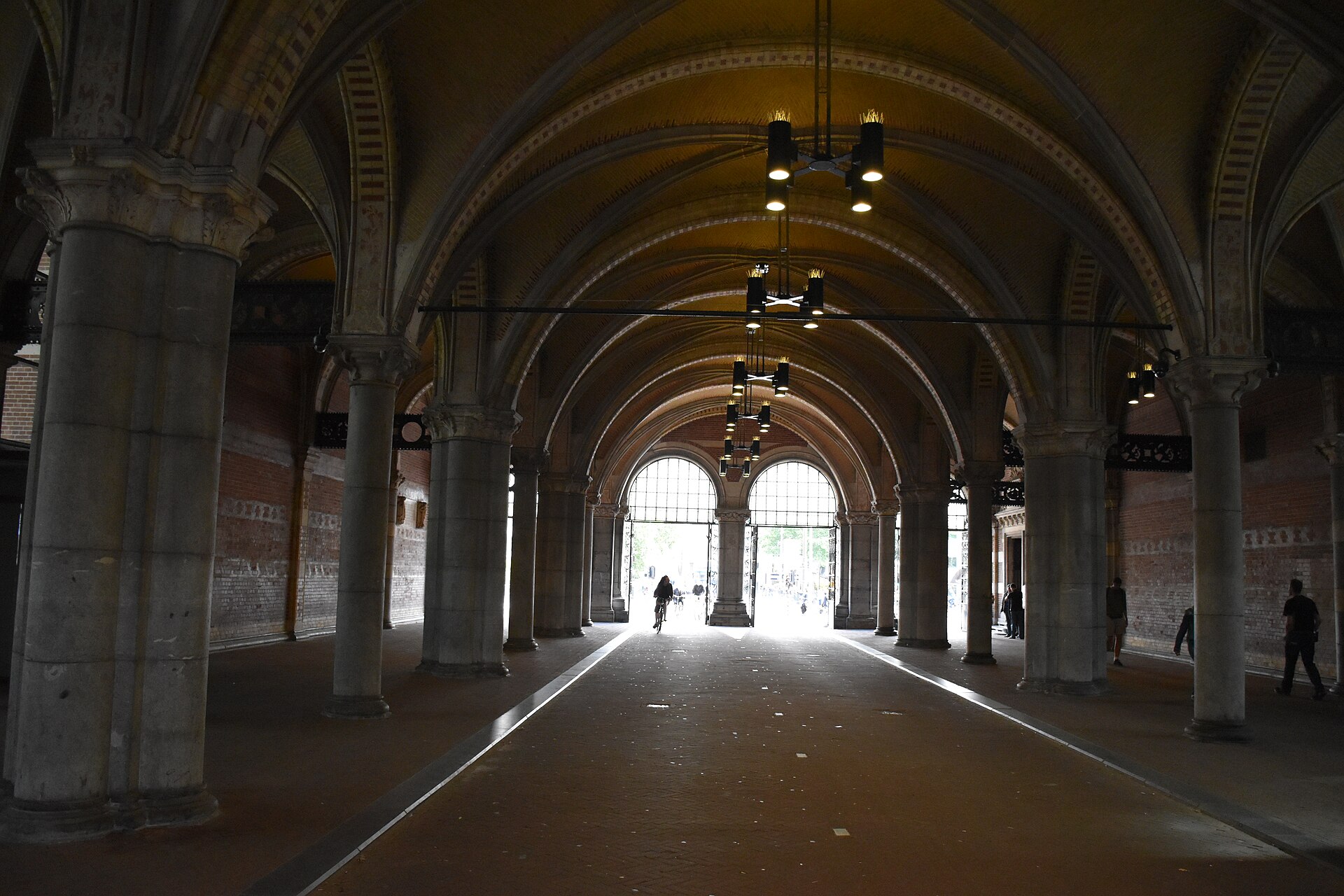 The vaulted public passage through the ground floor of the museum with a cyclist riding through it